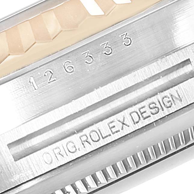 This close-up image shows the serial number and the "ORIG. ROLEX DESIGN" engraving on a Rolex Datejust 41 126333 Men's Steel and Gold (two tone) Black Dial 126333 Men's Steel and Gold (two tone) Black Dial watch.