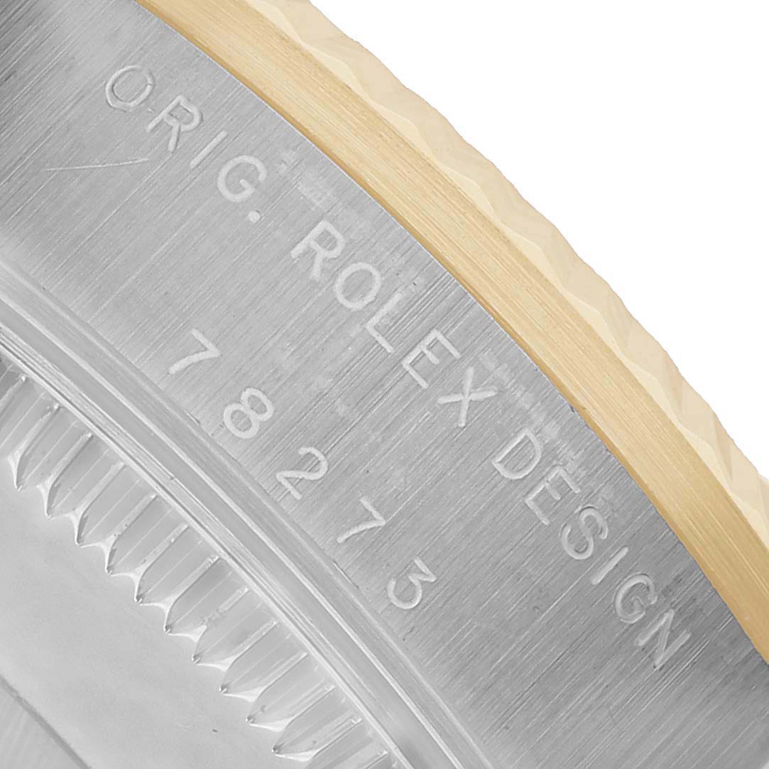 The image shows a close-up of the side of the Rolex Datejust 78273 Women's Steel and Gold (two tone) White Dial watch case, displaying engraved text and part of the bezel.