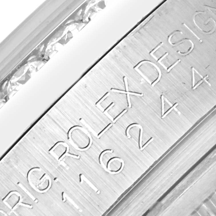 The image shows a close-up of the Rolex Datejust 116244 Men's Stainless Steel Mother of Pearl Dial 116244 Men's Stainless Steel Mother of Pearl Dial's metal surface with engraved text details.