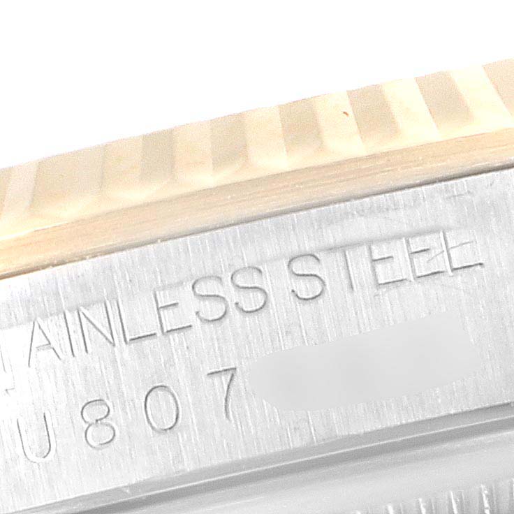 This image shows a close-up of the fluted bezel and engraving on the side of the case of a Rolex Datejust 16233 Men
s Steel and Gold (two tone) Mother of Pearl Dial 16233 Men
s Steel and Gold (two tone) Mother of Pearl Dial model.