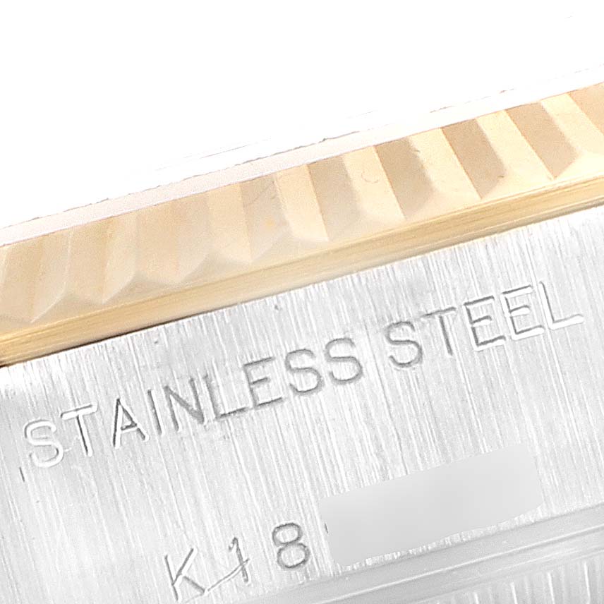 This close-up image showcases the bezel and part of the case of a Rolex Datejust 79173 Women's Steel and Gold (two tone) Red Dial 79173 Women's Steel and Gold (two tone) Red Dial watch, highlighting the "Stainless Steel" engraving.