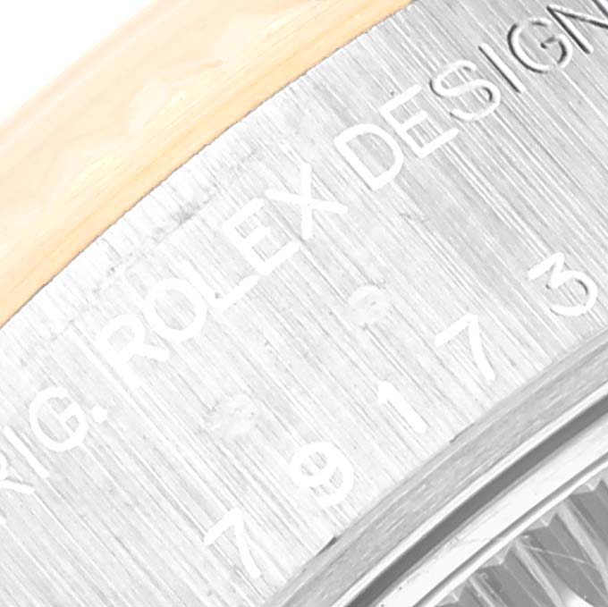A close-up of the caseback of a Rolex Datejust 79173 Women's Steel and Gold (two tone) Silver Dial 79173 Women's Steel and Gold (two tone) Silver Dial showing the engraved "ROLEX DESIGN" text and part of the serial number.