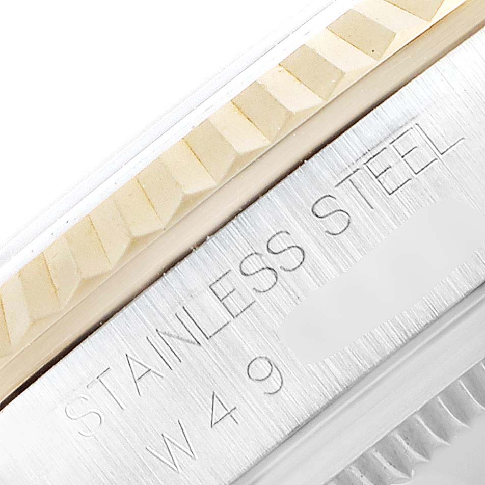 This close-up image of a Rolex Datejust 16233 Men's Steel and Gold (two tone) White Dial 16233 Men's Steel and Gold (two tone) White Dial shows the fluted bezel and part of the case with "STAINLESS STEEL" engraved.