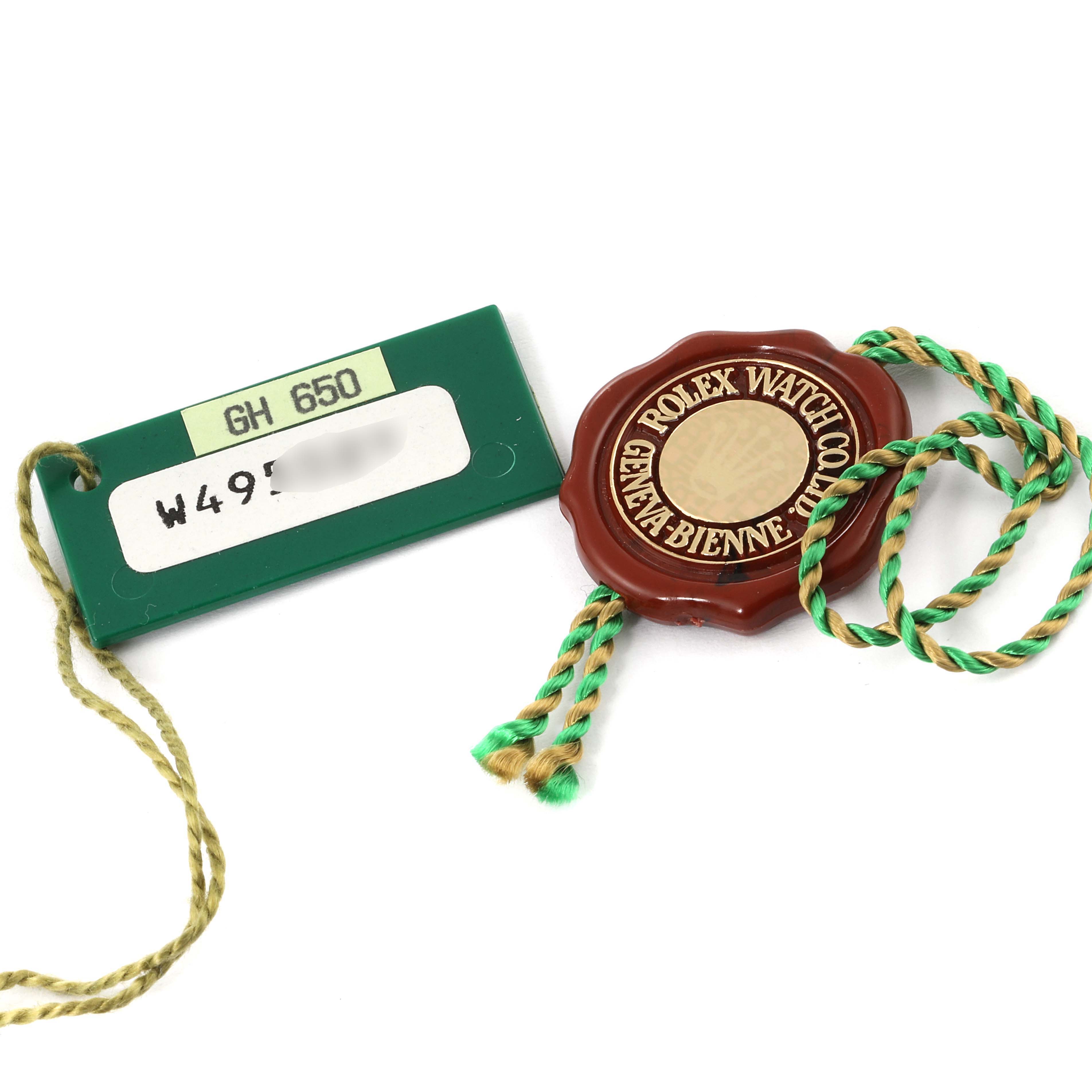 The image shows a green Rolex tag and a brown Rolex seal tag with a green and gold string, accessories for a Datejust model by Rolex.