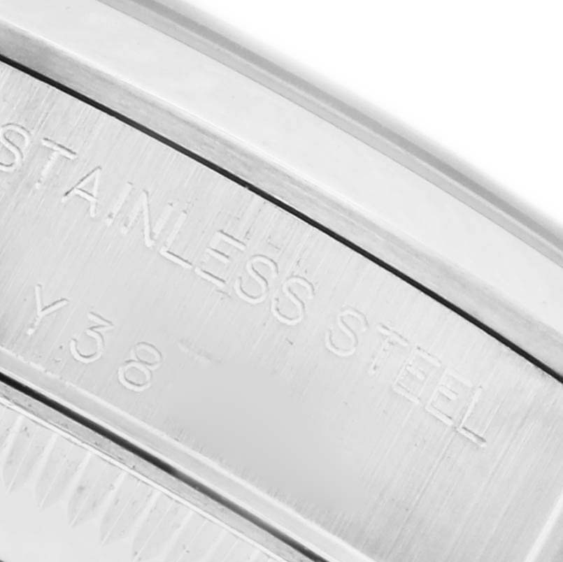 The image shows a close-up of the engraved side of a Rolex Oyster Perpetual 76080 Women's Stainless Steel Silver Dial 76080 Women's Stainless Steel Silver Dial watch, highlighting its "STAINLESS STEEL" marking.