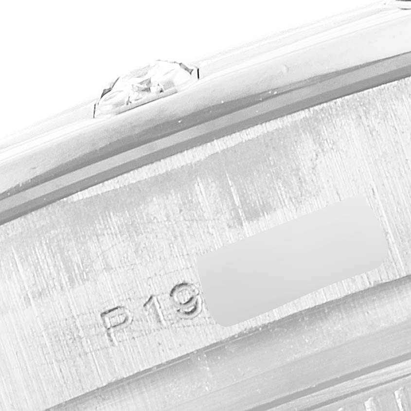 This image shows a close-up of the side of a Rolex Pearlmaster 80319 Women
s White Gold Silver Dial 80319 Women
s White Gold Silver Dial watch focusing on the edge with a diamond and engraved markings.