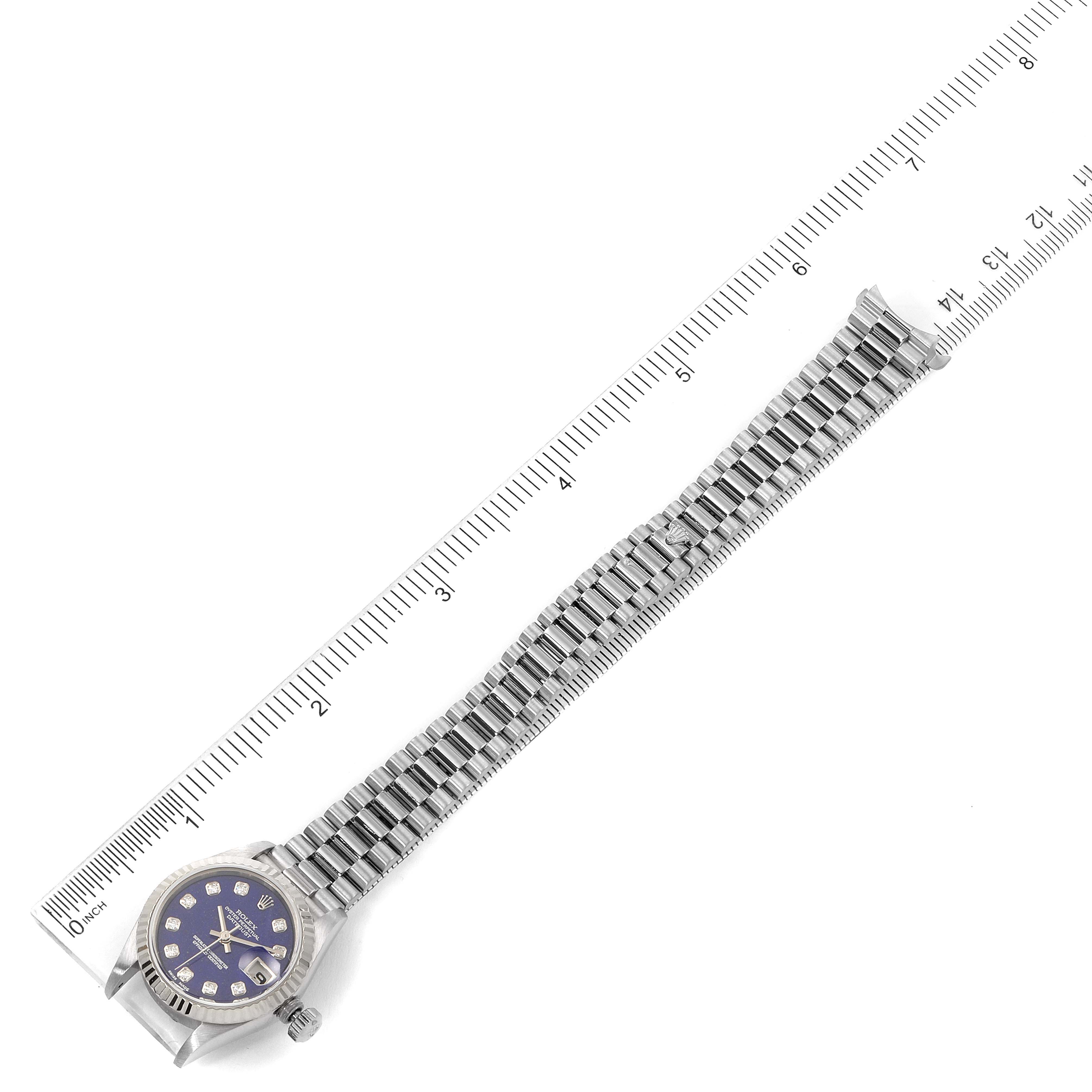The image shows a top view of a Rolex President 69179 Women's White Gold Blue Dial 69179 Women's White Gold Blue Dial watch with its band fully extended against a ruler.