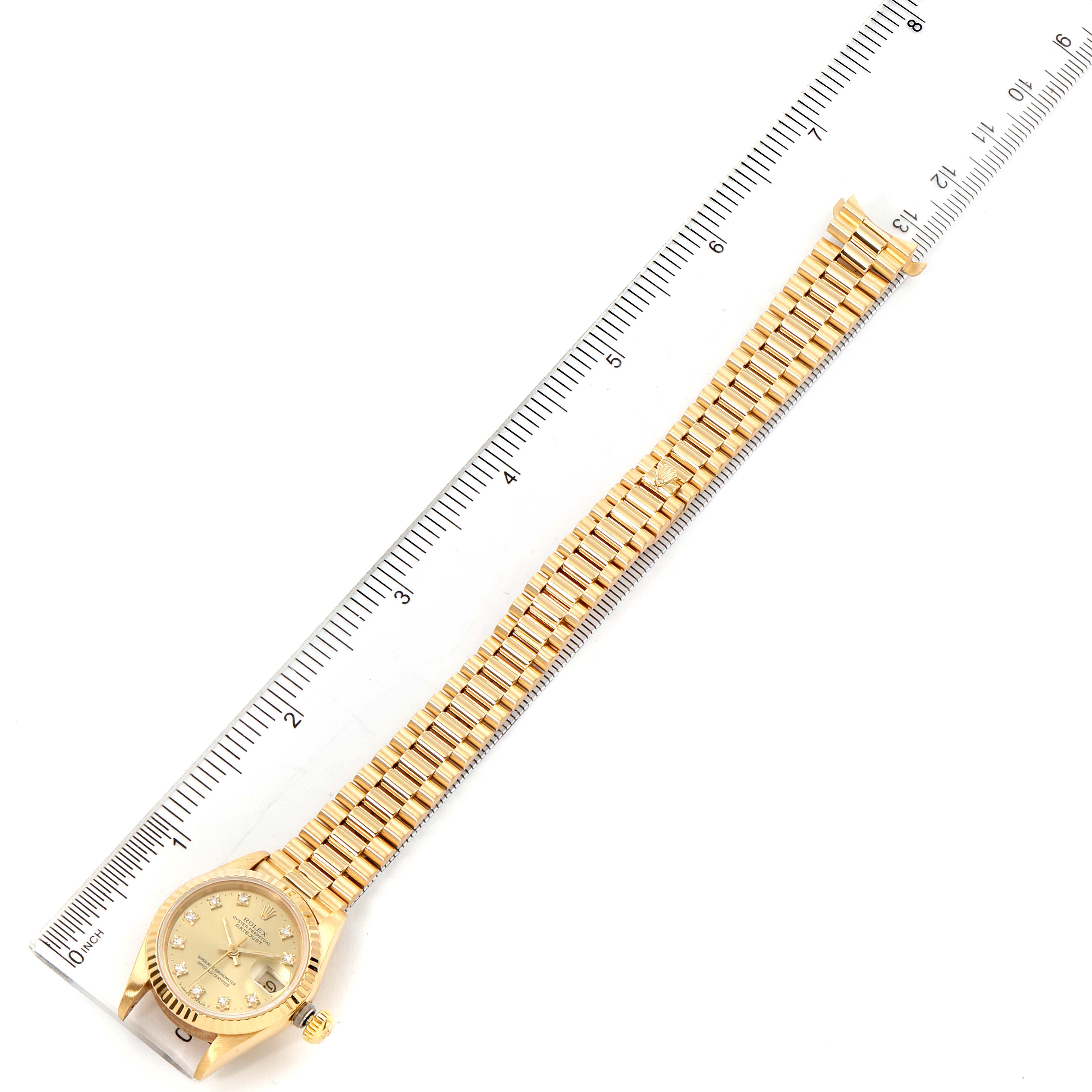 The image shows a Rolex President 69178 Women's Yellow Gold Champagne Dial 69178 Women's Yellow Gold Champagne Dial model watch placed alongside a ruler, capturing the full face, bracelet, and clasp.