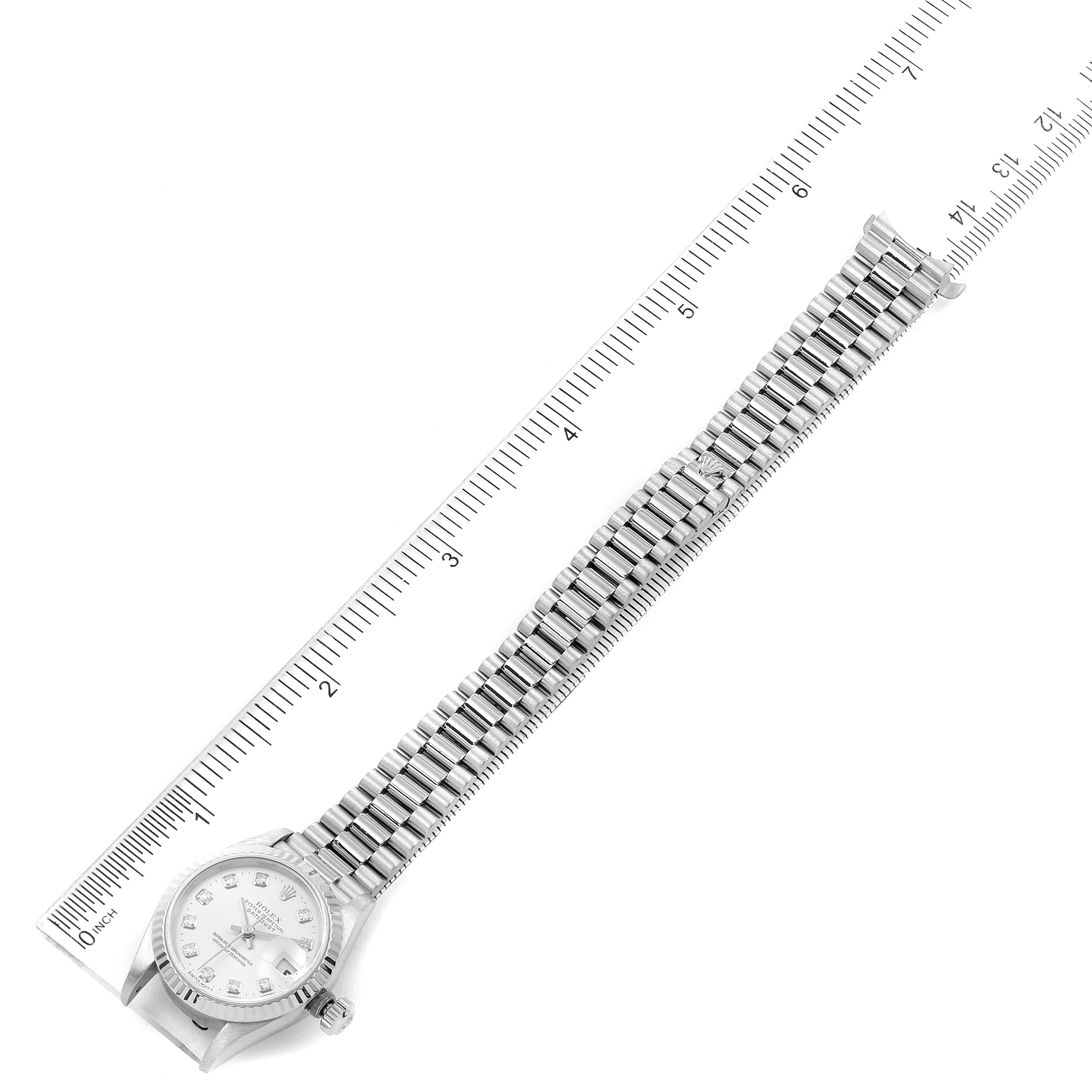 The image shows a top-down view of a Rolex President 79179 Women's White Gold Silver Dial 79179 Women's White Gold Silver Dial watch, displaying its face, bezel, band, and clasp along with a measurement ruler.