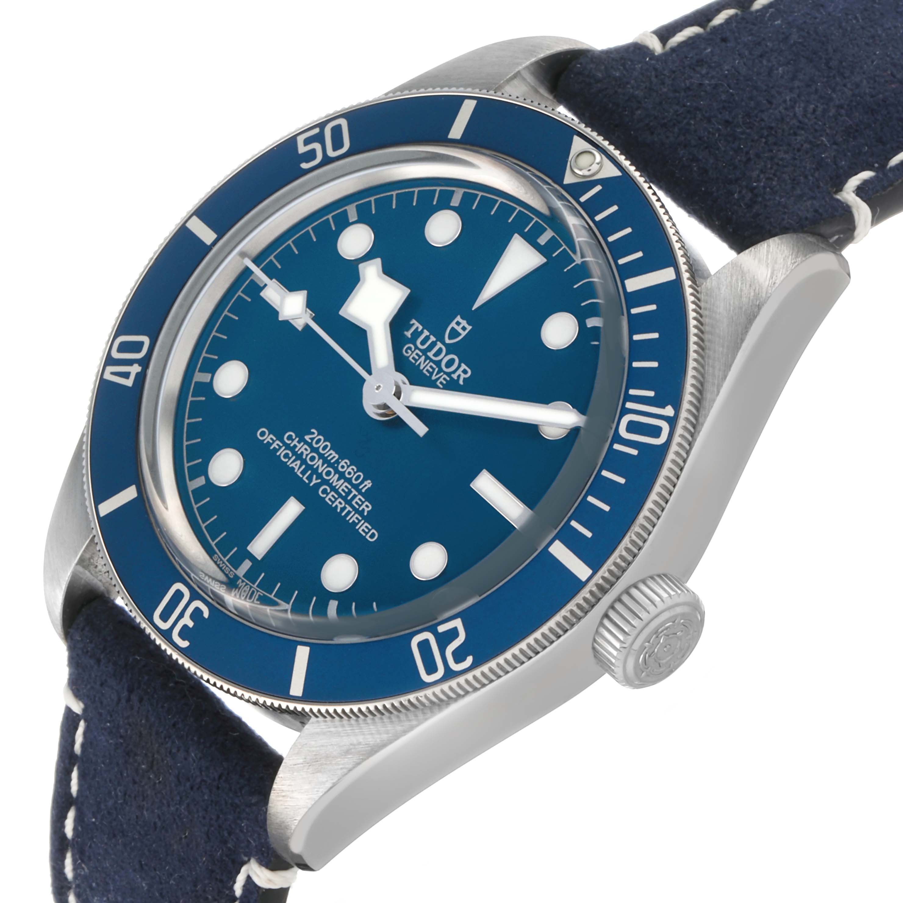 The Tudor Heritage Black Bay 79030 Men's Stainless Steel Blue Dial watch is shown at an angle highlighting the blue bezel, dial, and crown with a leather strap.