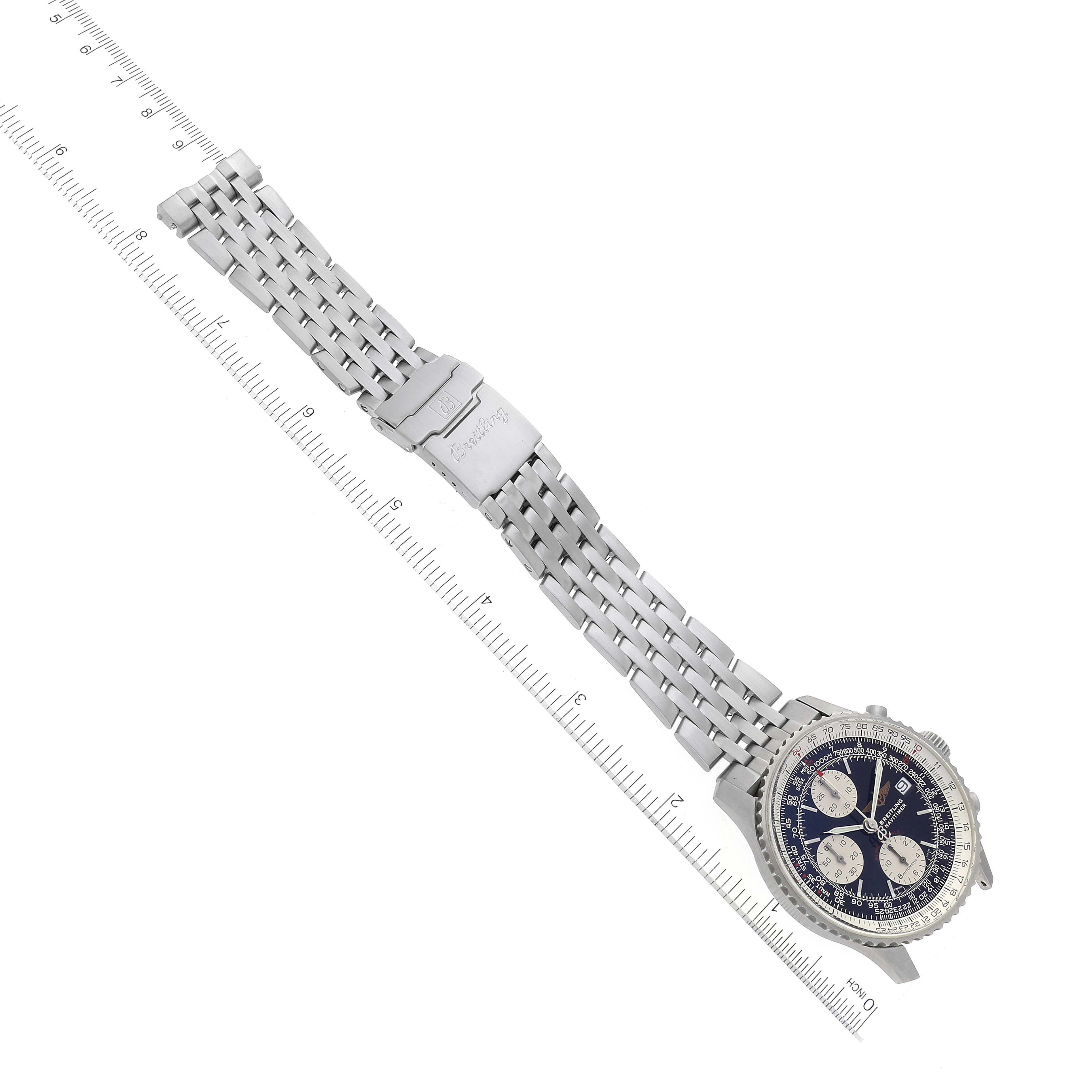 The image shows a Breitling Navitimer A13330 Men
s Stainless Steel Black Dial A13330 Men
s Stainless Steel Black Dial watch with a stainless steel bracelet laid flat, angled diagonally with a ruler for scale.
