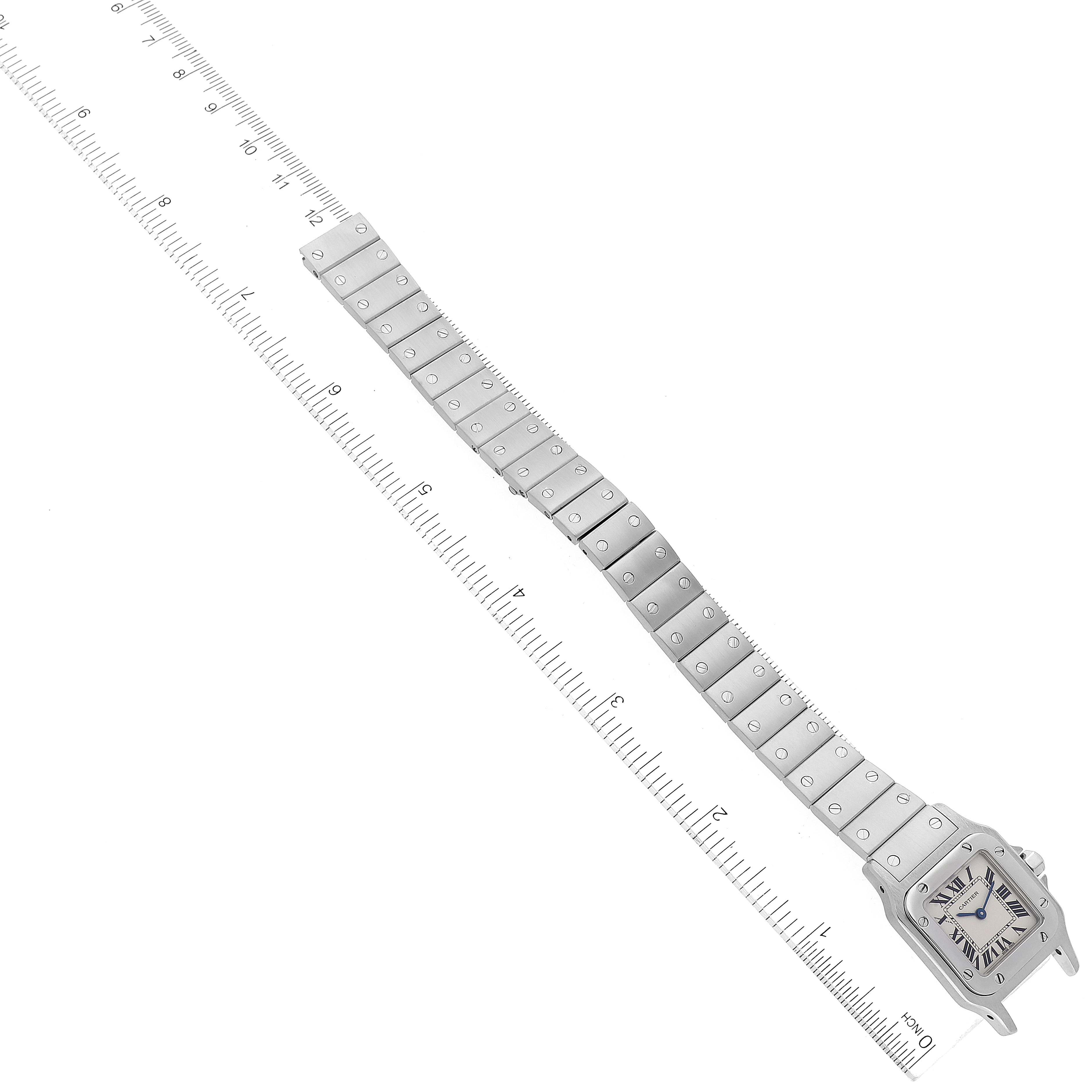The image shows the Cartier Santos W20056D6 Women's Stainless Steel Silver Dial W20056D6 Women's Stainless Steel Silver Dial watch laid flat with its face and full metal bracelet visible, next to a ruler.