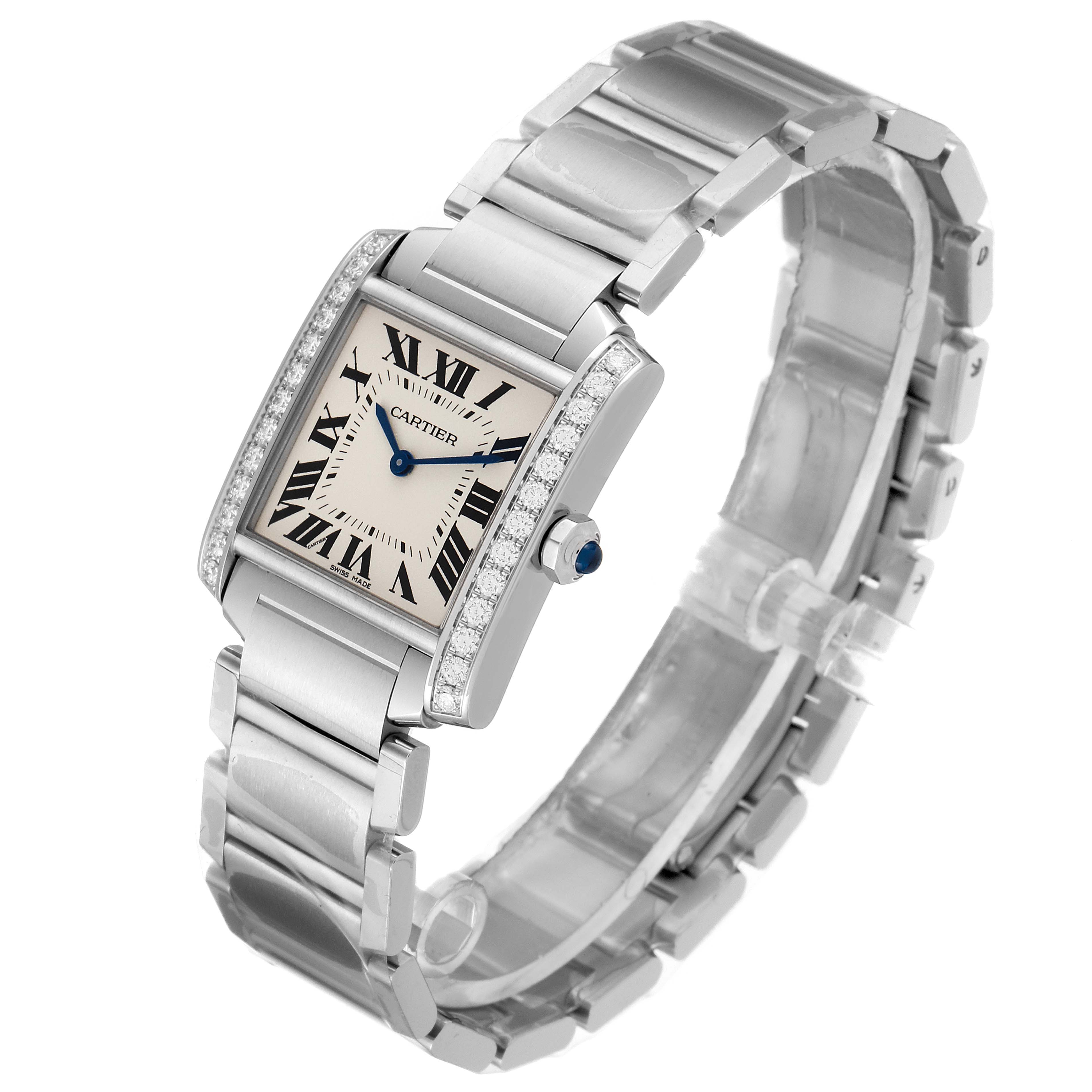 The Cartier Tank Francaise W4TA0009 Women's Stainless Steel Silver Dial W4TA0009 Women's Stainless Steel Silver Dial watch is shown at an angled view, displaying its face, Roman numerals, bracelet, and crown with a blue gem.