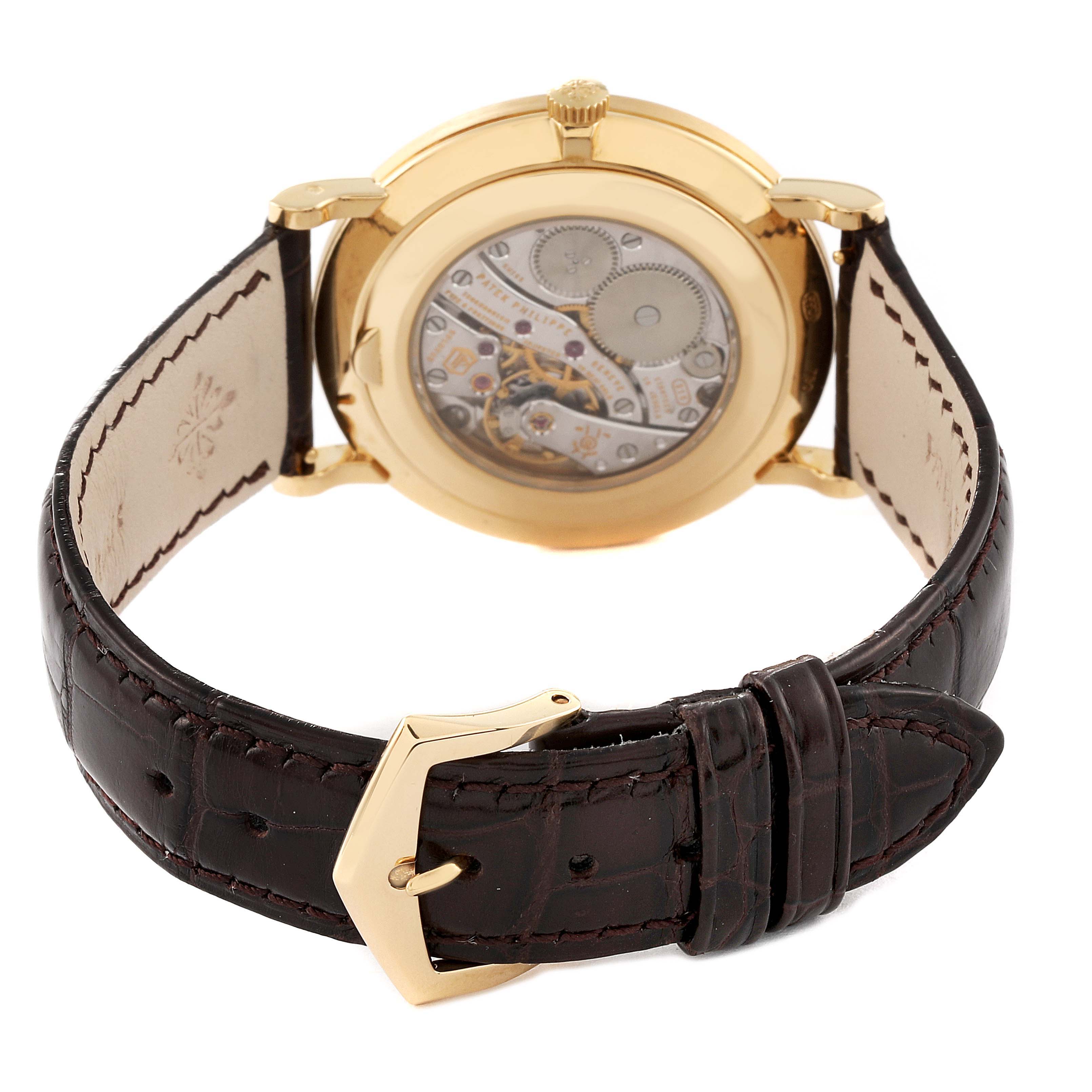 The image shows the back view of a Patek Philippe Calatrava 5119J Men
s Yellow Gold White Dial 5119J Men
s Yellow Gold White Dial watch, highlighting its movement and leather strap with a gold buckle.
