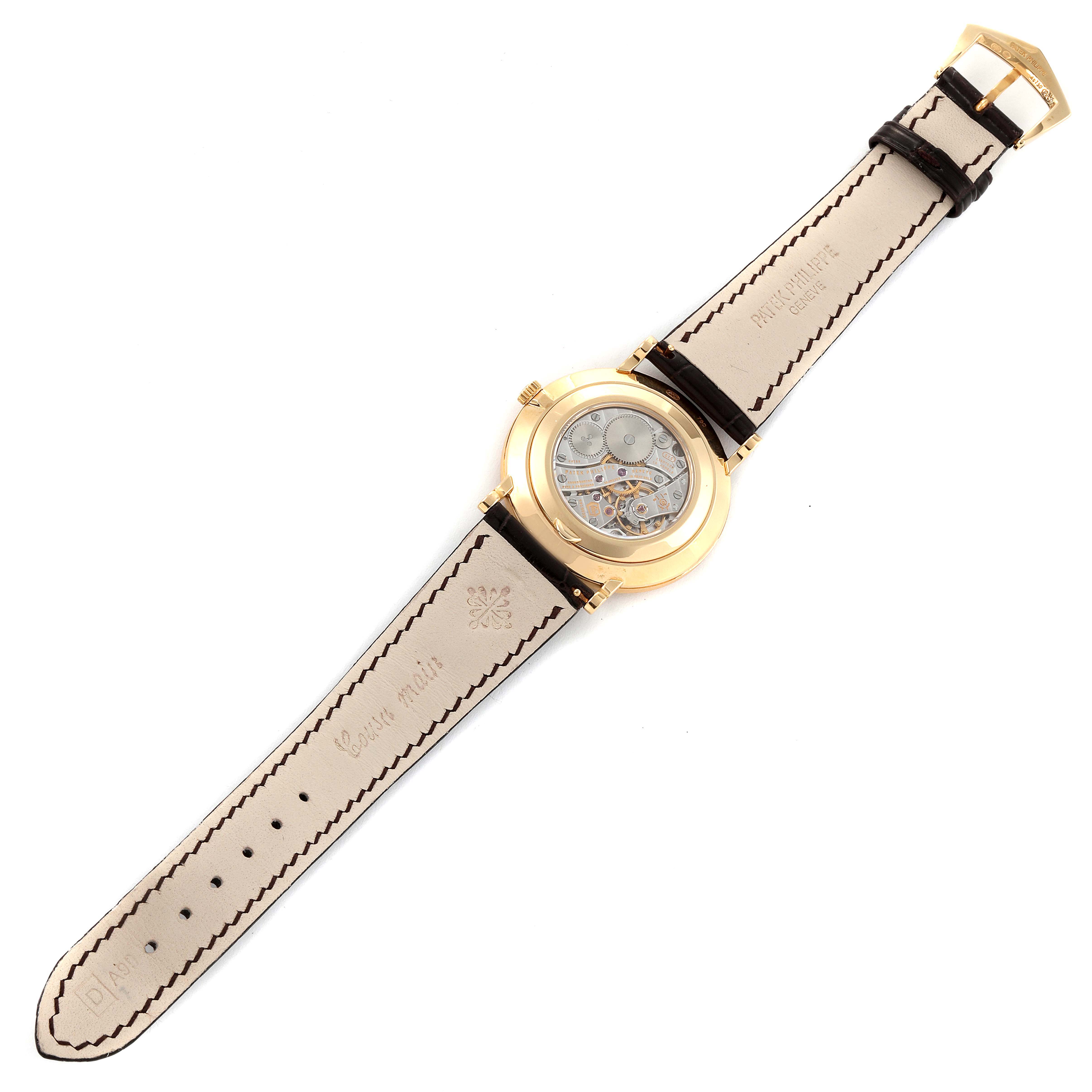 The Patek Philippe Calatrava 5119J Men
s Yellow Gold White Dial 5119J Men
s Yellow Gold White Dial watch is shown from the back, displaying its movement and the leather strap.