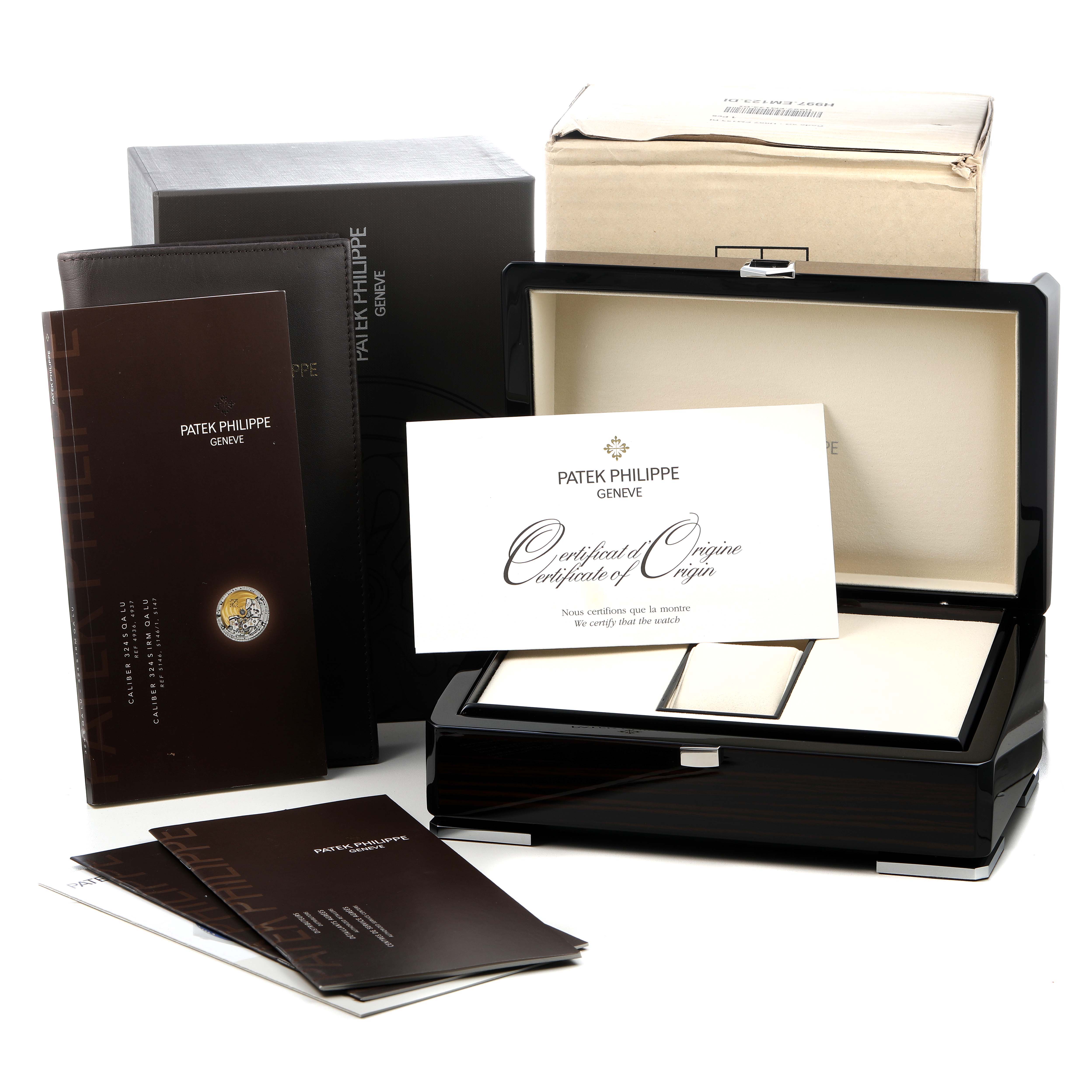 The image shows the packaging and accessories for a Patek Philippe Complications 5146/1J-001 Men's Yellow Gold White Dial watch, including a box, certificates, and booklets.