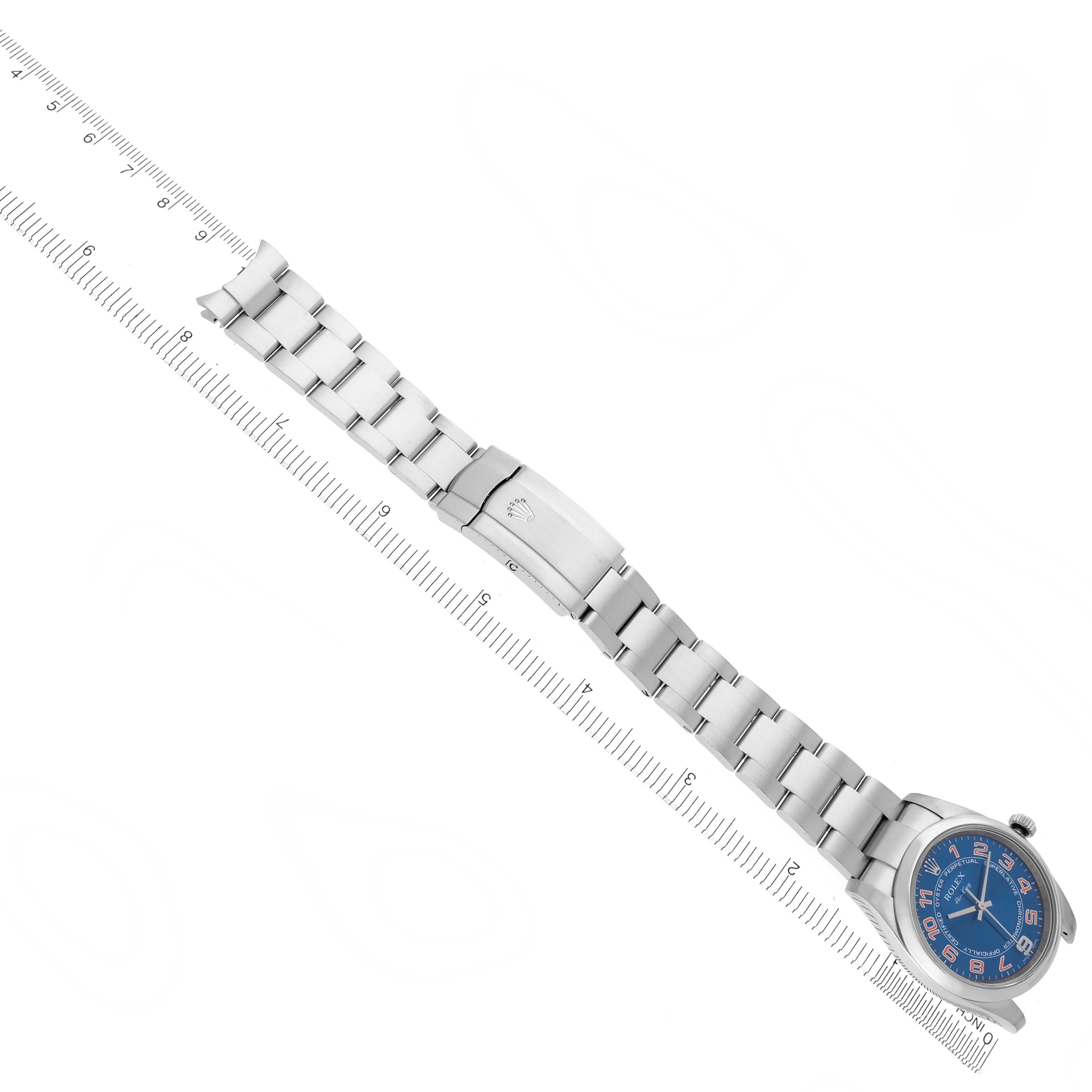 The image shows a top-down view of a Rolex Air-King 114200 Men's Stainless Steel Blue Dial 114200 Men's Stainless Steel Blue Dial watch with a metal bracelet, next to a ruler for scale.