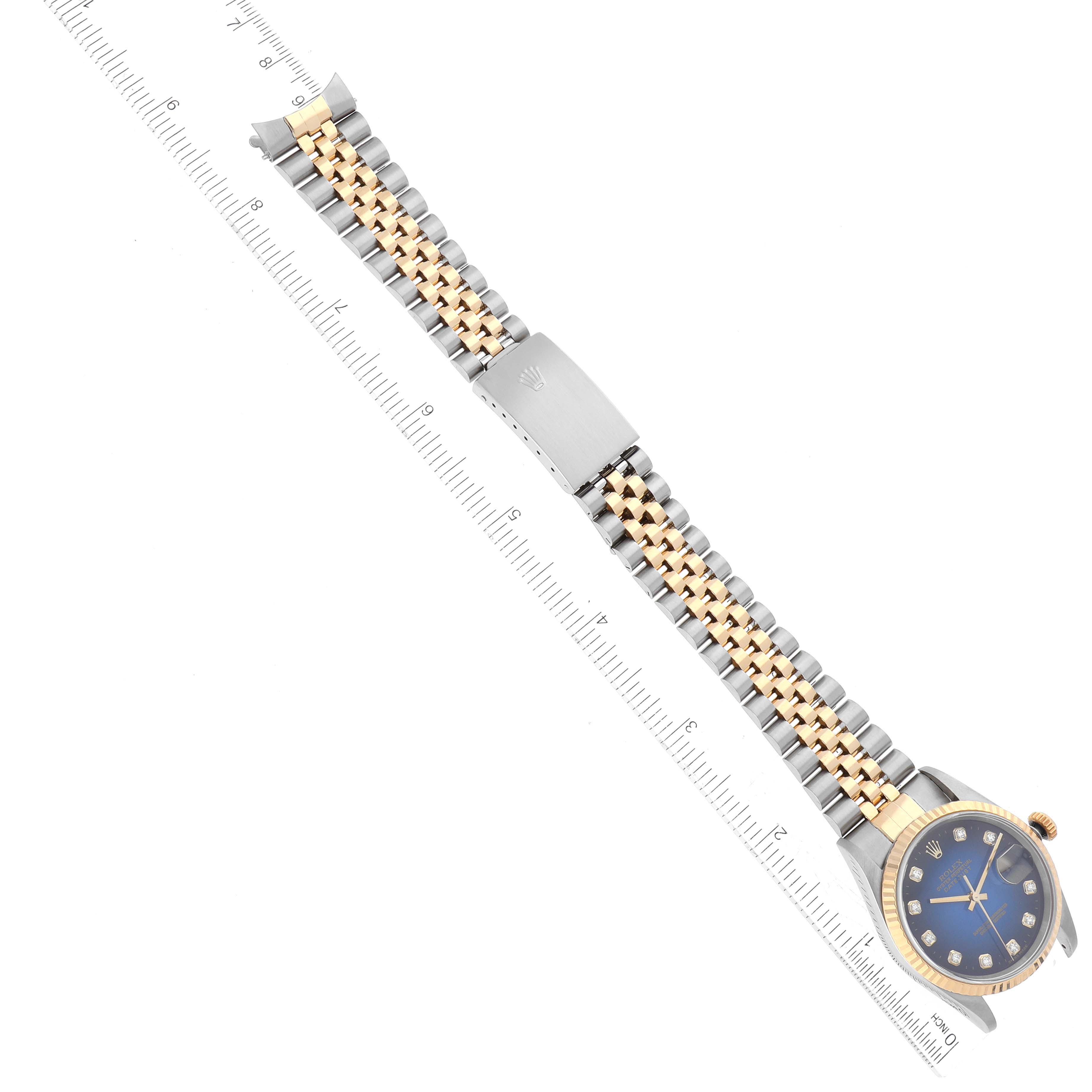 The image shows a top-down view of a Rolex Datejust 16233 Men's Steel and Gold (two tone) Blue Dial 16233 Men's Steel and Gold (two tone) Blue Dial watch with its entire bracelet and clasp visible alongside a ruler for scale.