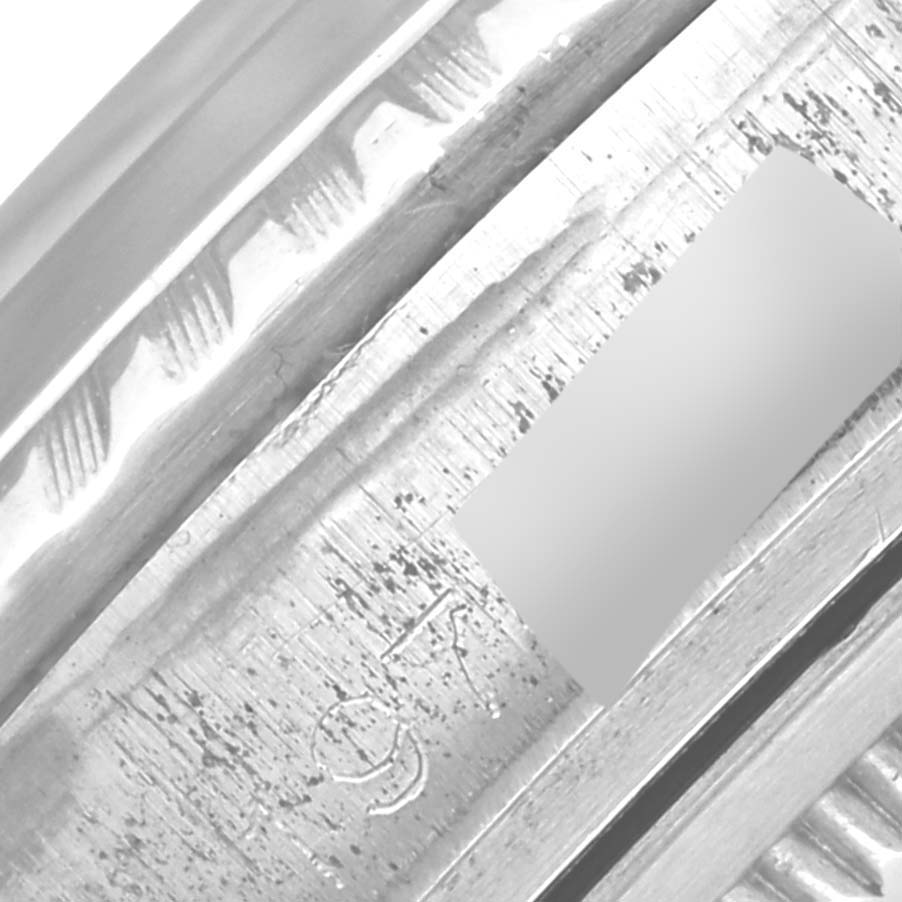 The image shows a close-up of the Rolex Datejust 1603 Men
s Stainless Steel Silver Dial 1603 Men
s Stainless Steel Silver Dial watch bezel and part of the case, focusing on detail and texture.