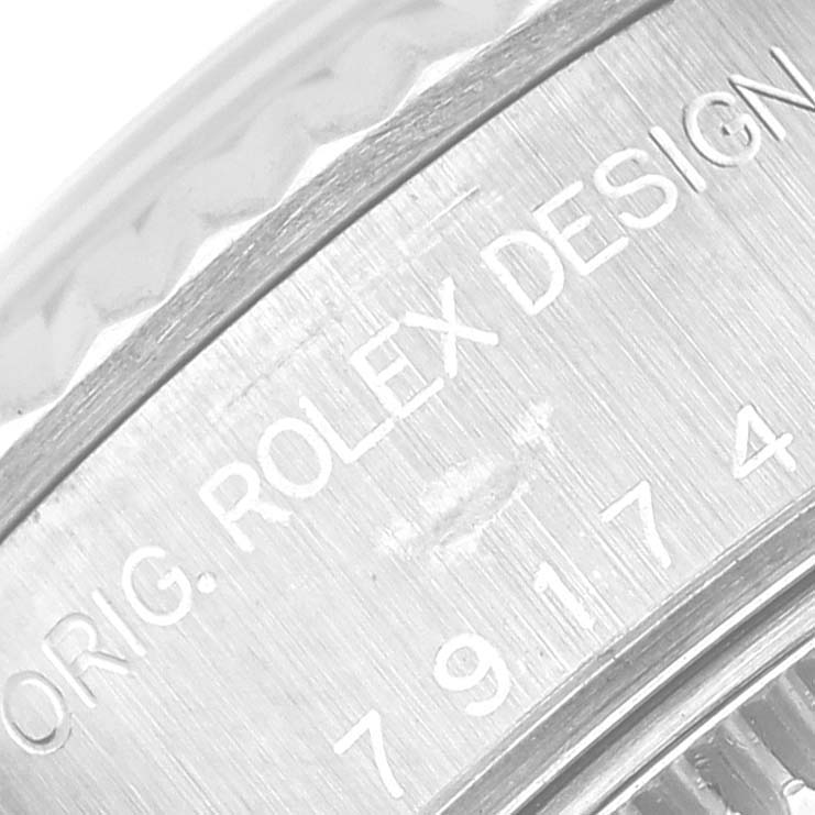 This close-up image shows part of the bezel and engraved side of a Rolex Datejust 79174 Women's Stainless Steel White Dial 79174 Women's Stainless Steel White Dial watch with "Rolex Design" inscription.