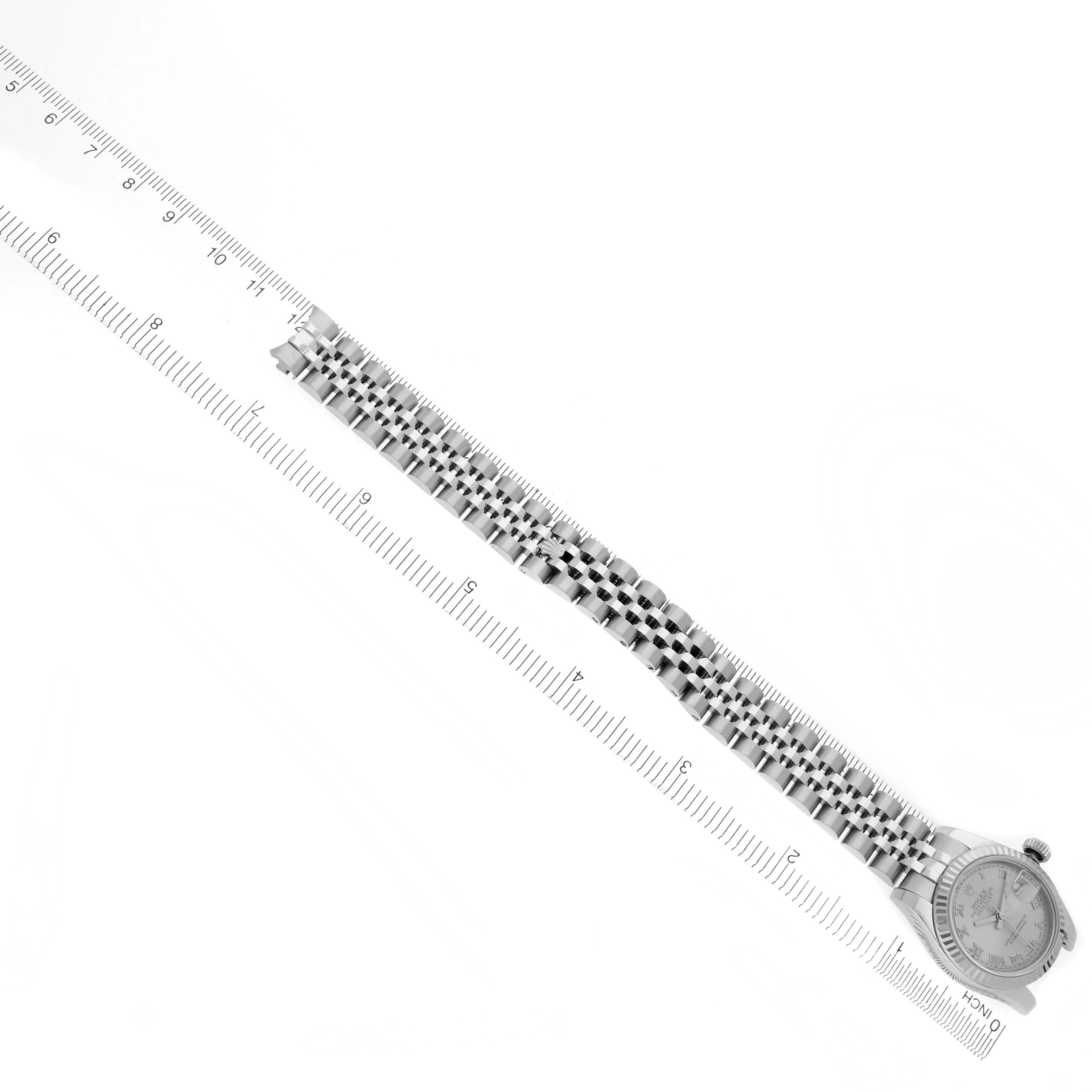 The image shows a Rolex Datejust 179174 Women's Stainless Steel Silver Dial 179174 Women's Stainless Steel Silver Dial watch at an overhead angle, featuring its bracelet and watch face alongside a ruler for scale.