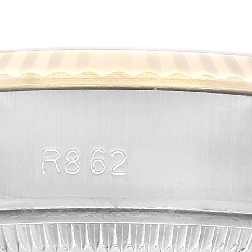 This close-up shows the side of the Rolex Datejust 69173 Women's Steel and Gold (two tone) Champagne Dial 69173 Women's Steel and Gold (two tone) Champagne Dial watch case and part of its bezel with an engraved number.