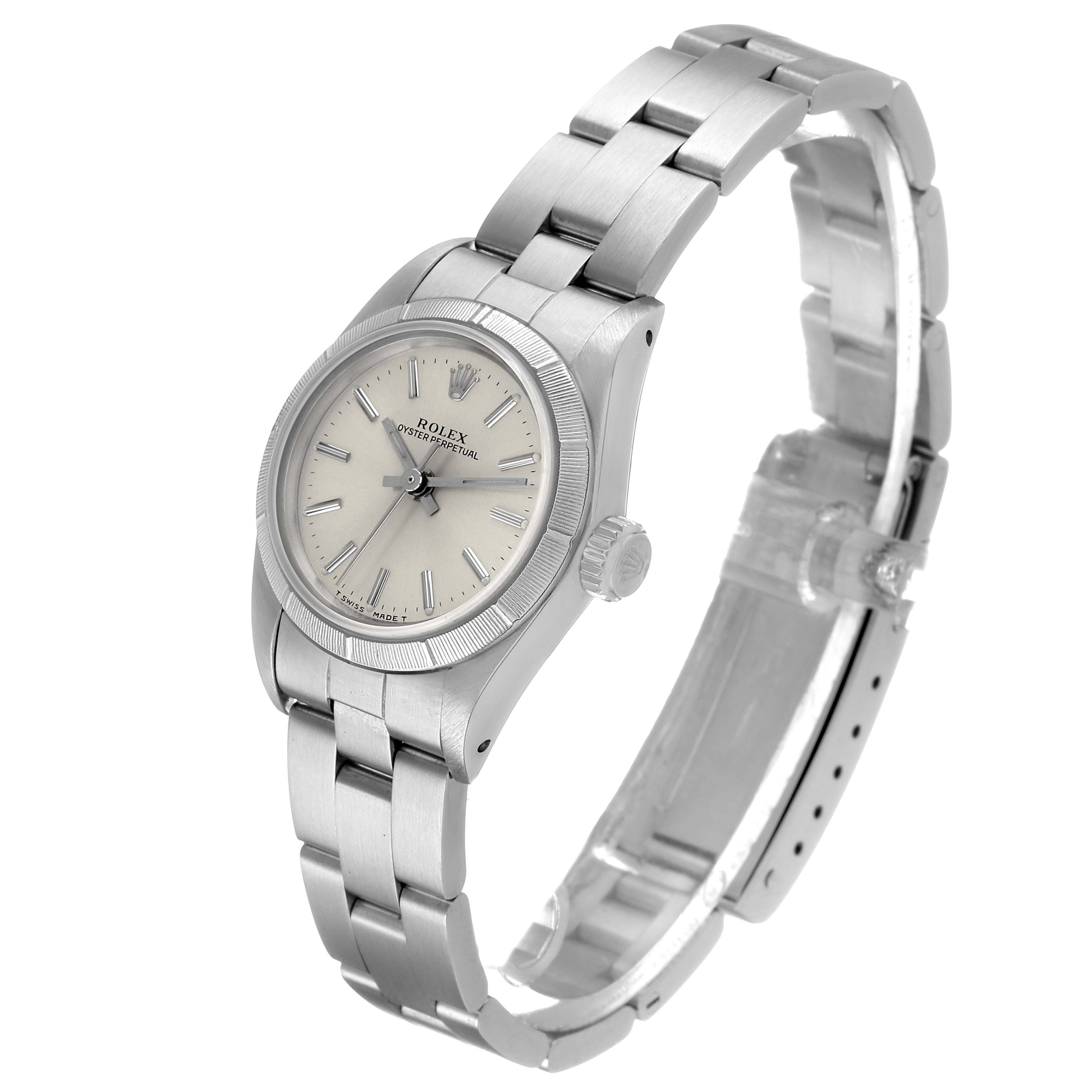 The Rolex Oyster Perpetual 67230 Women's Stainless Steel Silver Dial watch is shown at an angle highlighting the face, bezel, crown, and bracelet.