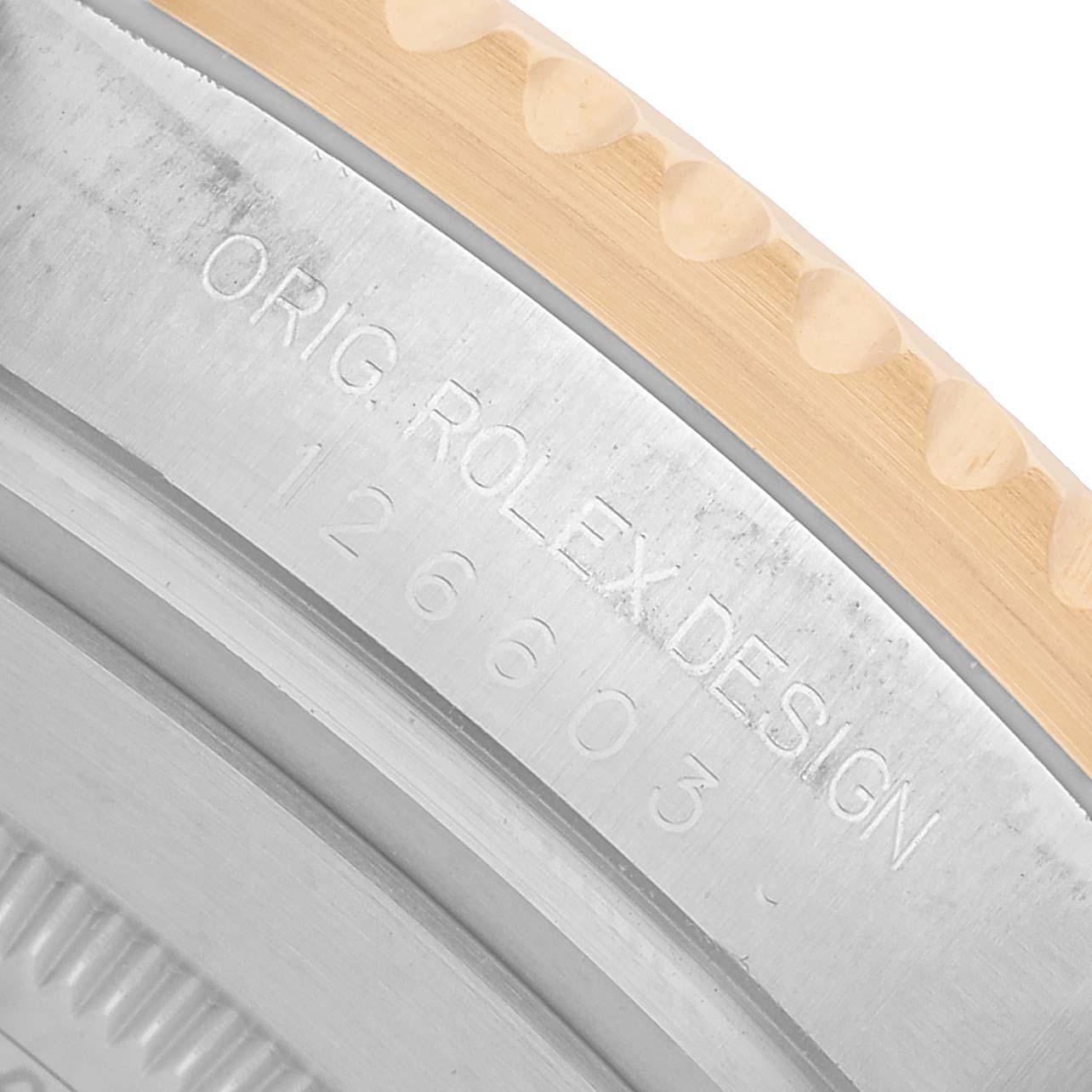 The image shows a close-up of the case edge and bezel of a Rolex Sea-Dweller 126603 Men's Steel and Gold (two tone) Black Dial, highlighting the engraving details.