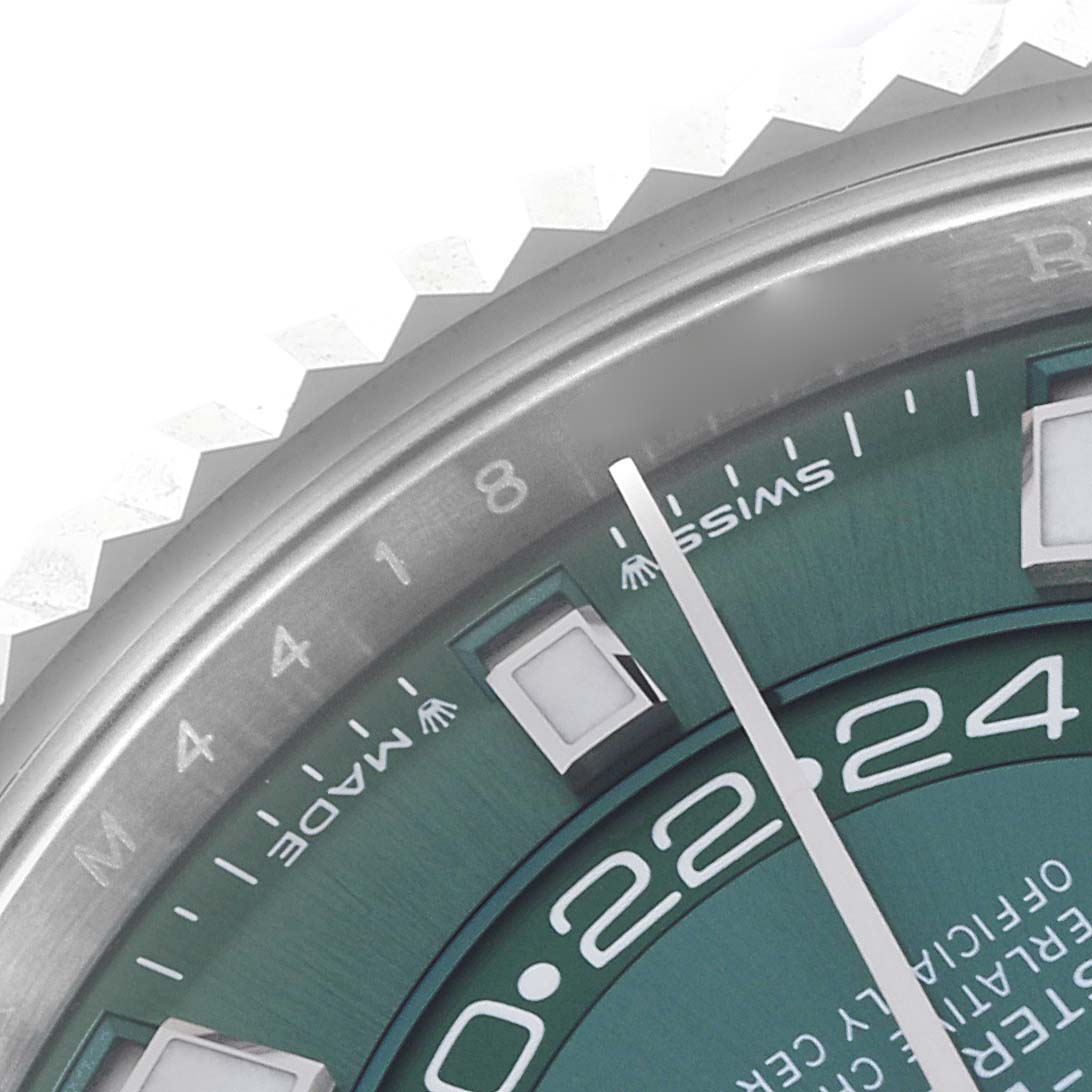 The image shows a close-up of the Rolex Sky-Dweller 336934 Men's Stainless Steel Green Dial's bezel and part of the dial, focusing on the hour markers and minute hand.