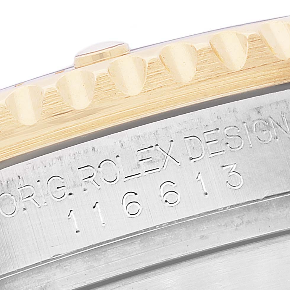The image shows a close-up view of the engravings and edge of the bezel on a Rolex Submariner 116613 Men's Steel and Gold (two tone) Blue Dial 116613 Men's Steel and Gold (two tone) Blue Dial model.