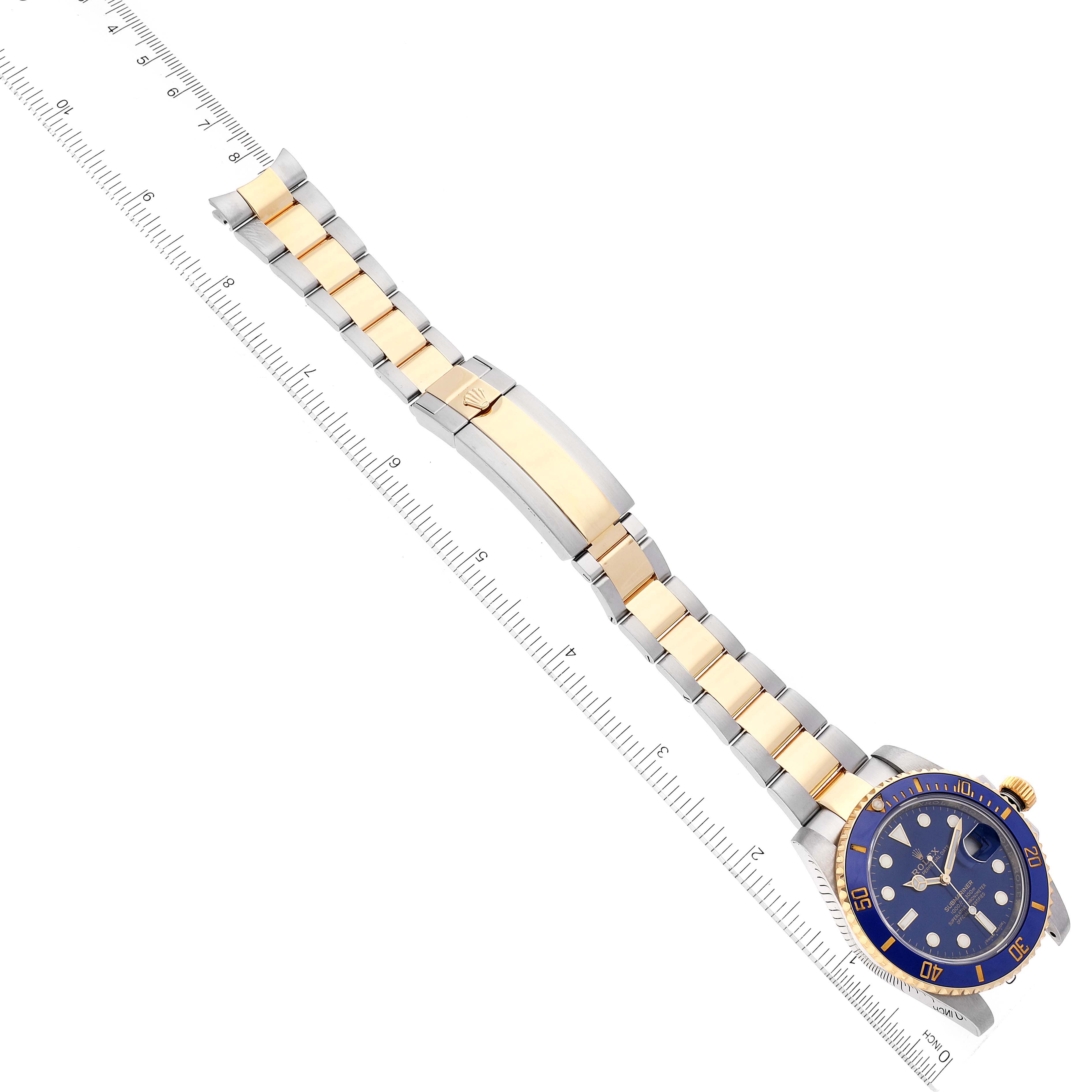 The image shows a Rolex Submariner 116613 Men's Steel and Gold (two tone) Blue Dial 116613 Men's Steel and Gold (two tone) Blue Dial watch laid flat, highlighting its band, clasp, and face at an angled top-down view.