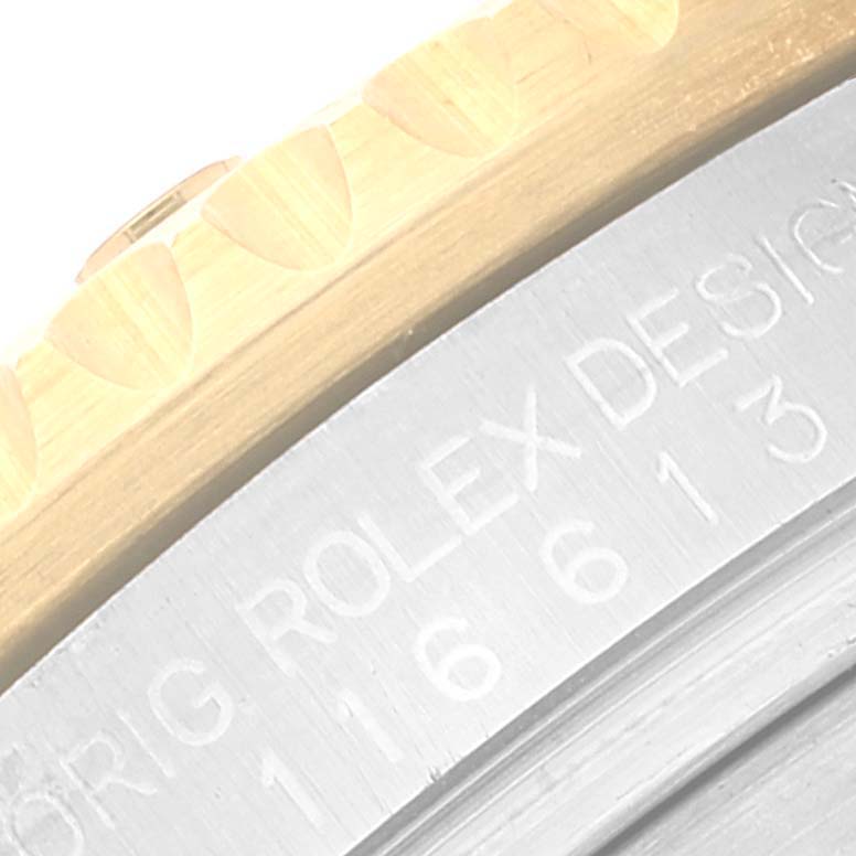 Close-up of the engraving on the side of a Rolex Submariner 116613 Men's Steel and Gold (two tone) Blue Dial 116613 Men's Steel and Gold (two tone) Blue Dial watch, showing part of the bezel and case.