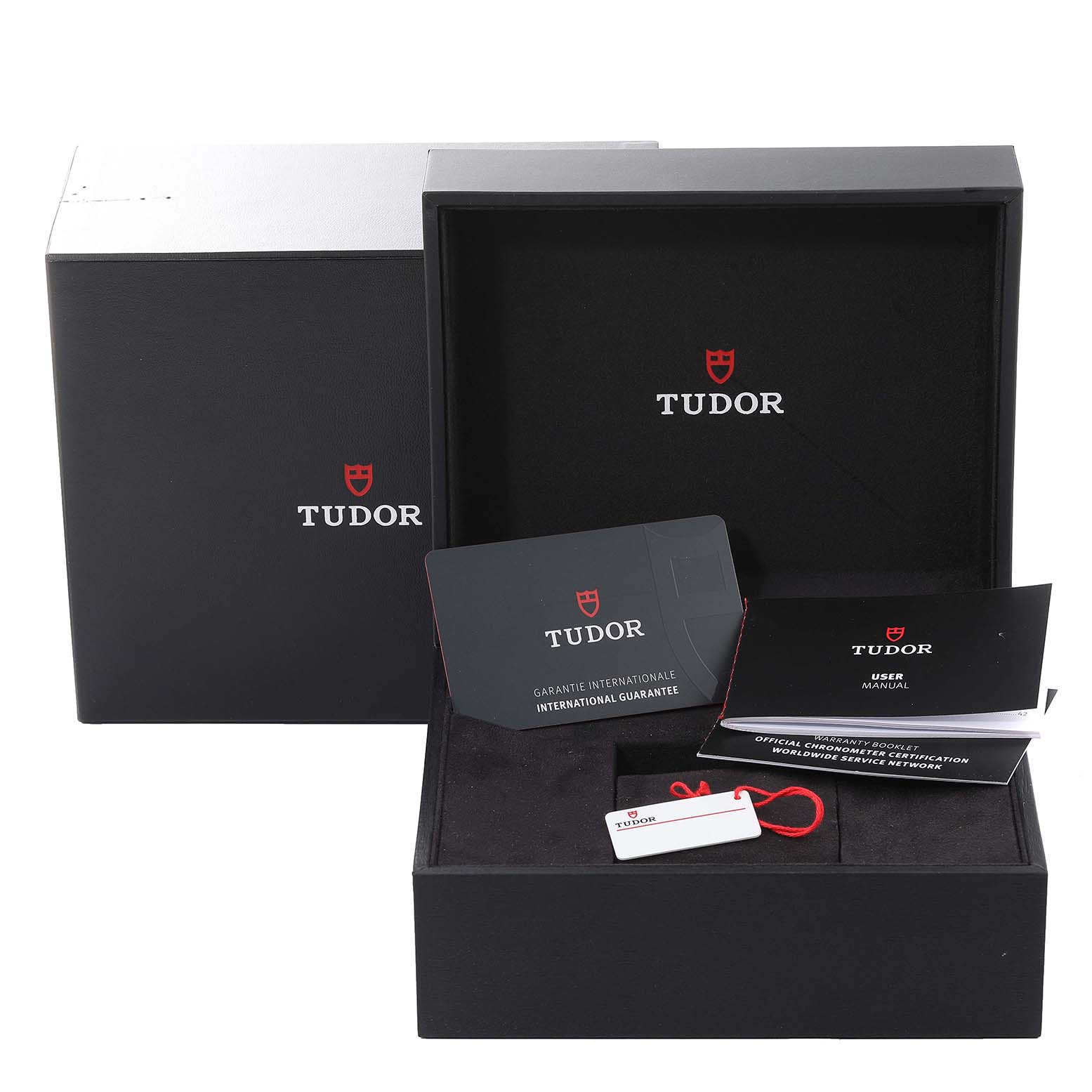 The image shows the packaging and documentation accessories for the Tudor Heritage Black Bay 79830RB Men
s Stainless Steel Black Dial 79830RB Men
s Stainless Steel Black Dial watch, including the box, guarantee, and user manual.