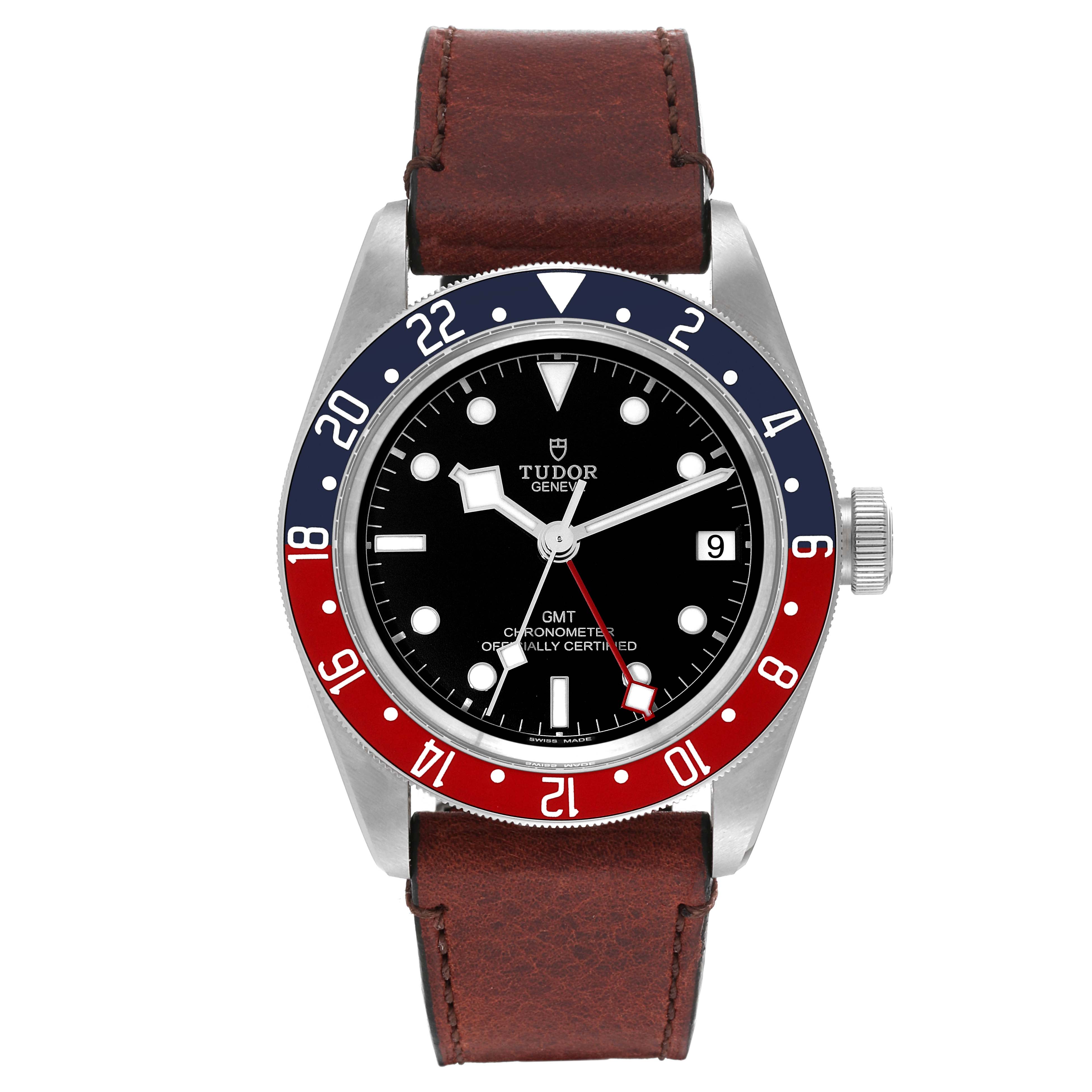The image shows a front view of the Tudor Heritage Black Bay 79830RB Men
s Stainless Steel Black Dial 79830RB Men
s Stainless Steel Black Dial GMT watch with a black dial, red and blue bezel, and a brown leather strap.