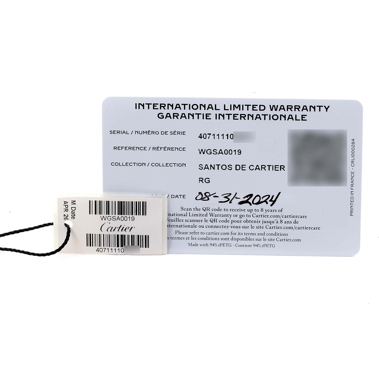 The image shows a warranty card for the Santos de Cartier watch with a tag attached.
