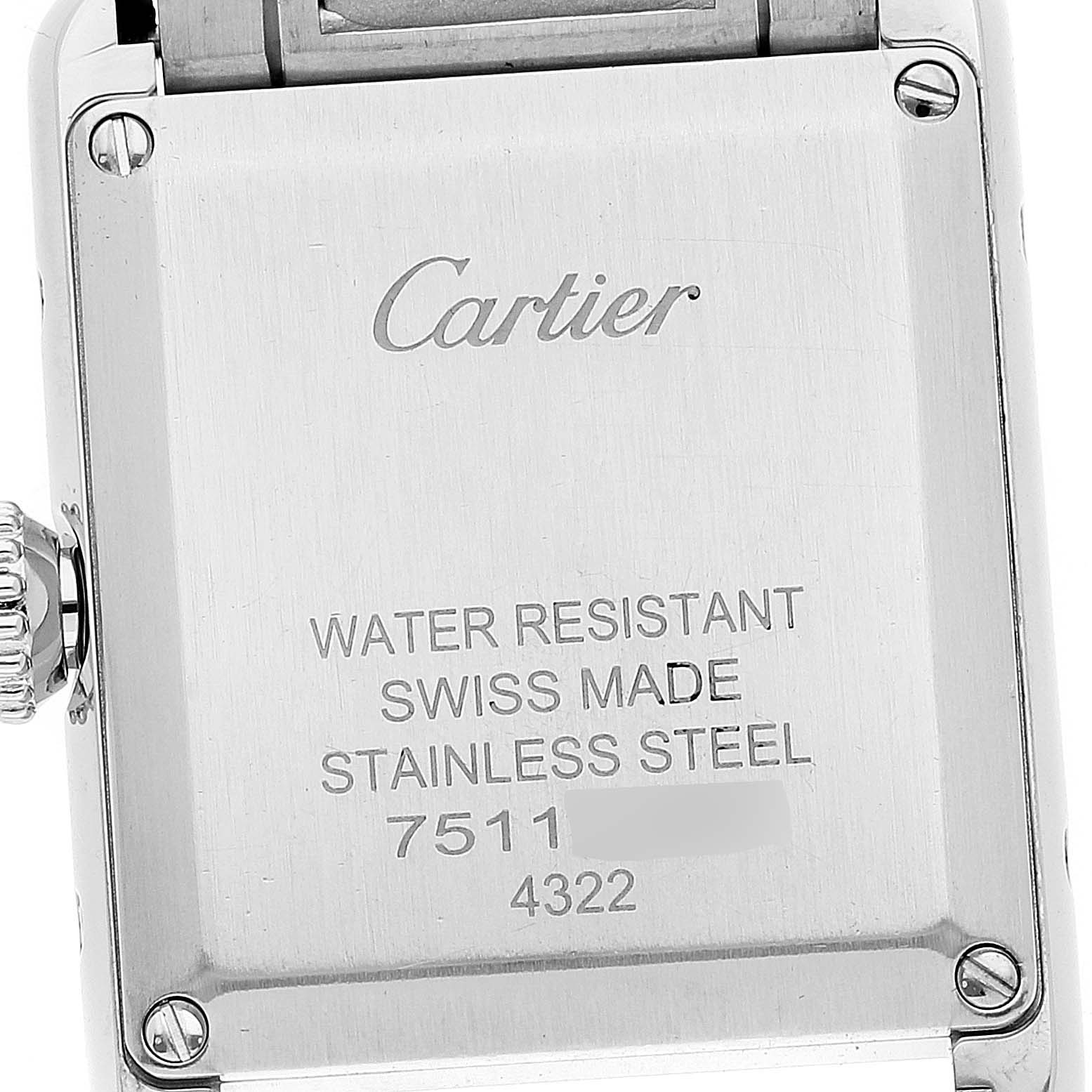The image shows the back case of the Tank Must model by Cartier, highlighting the inscriptions and screw details.