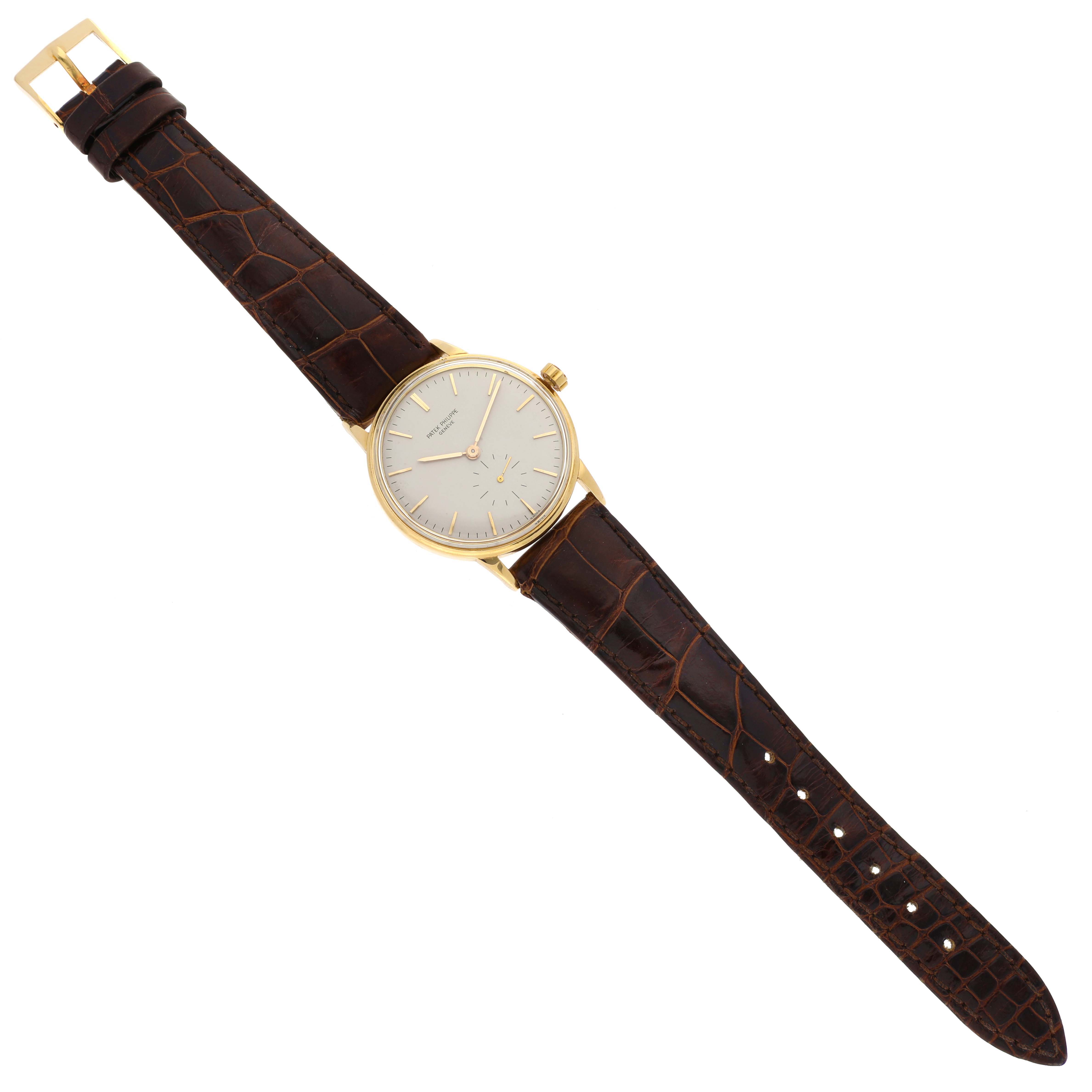 The image shows a Patek Philippe Calatrava 3425 Men's Yellow Gold Silver Dial 3425 Men's Yellow Gold Silver Dial watch from a top-down angle, displaying the dial, case, crown, strap, and buckle.