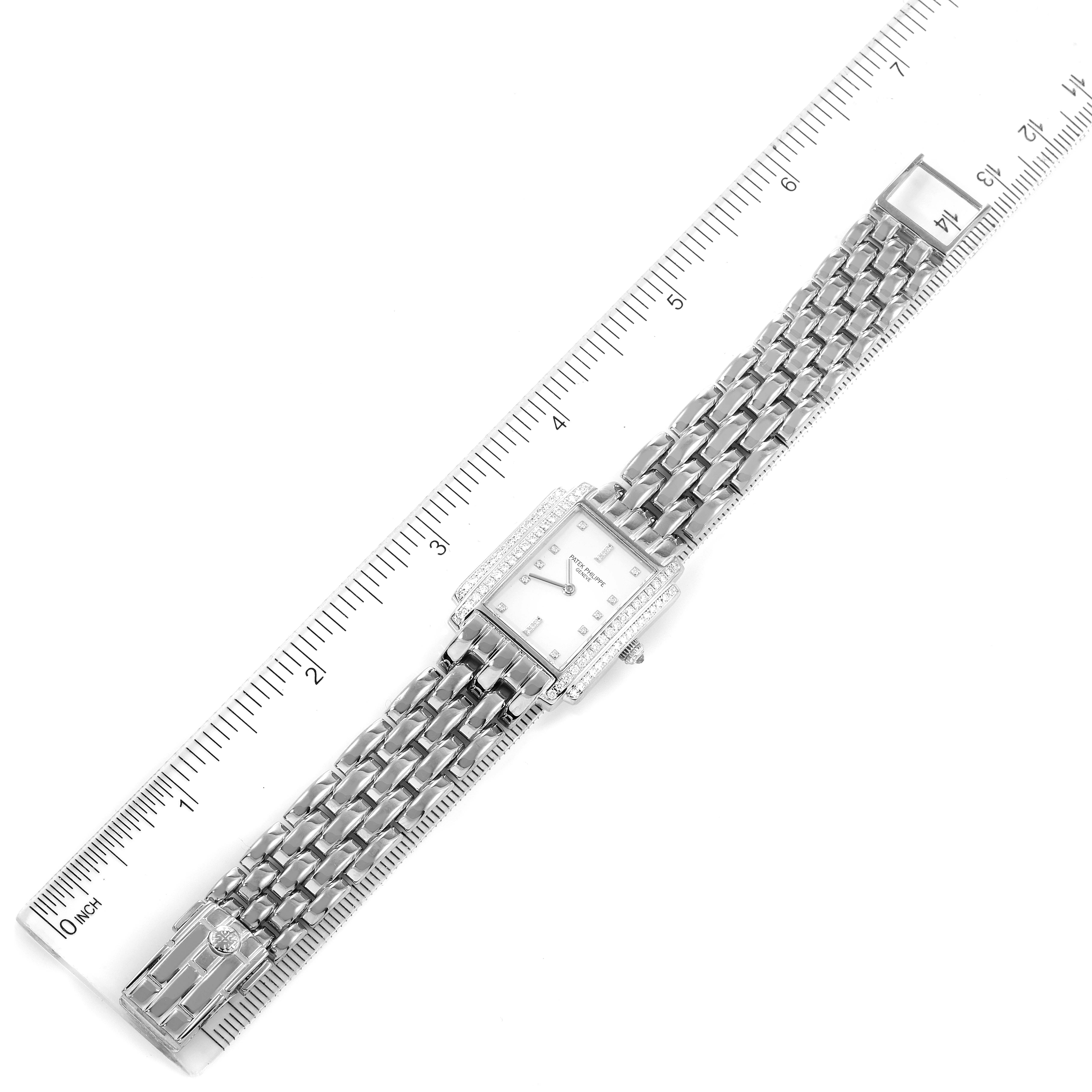 The image shows a top-down view of a Patek Philippe Gondolo 4825G/101 Women's White Gold White Dial 4825G/101 Women's White Gold White Dial watch with a metal bracelet, placed along a ruler for scale.