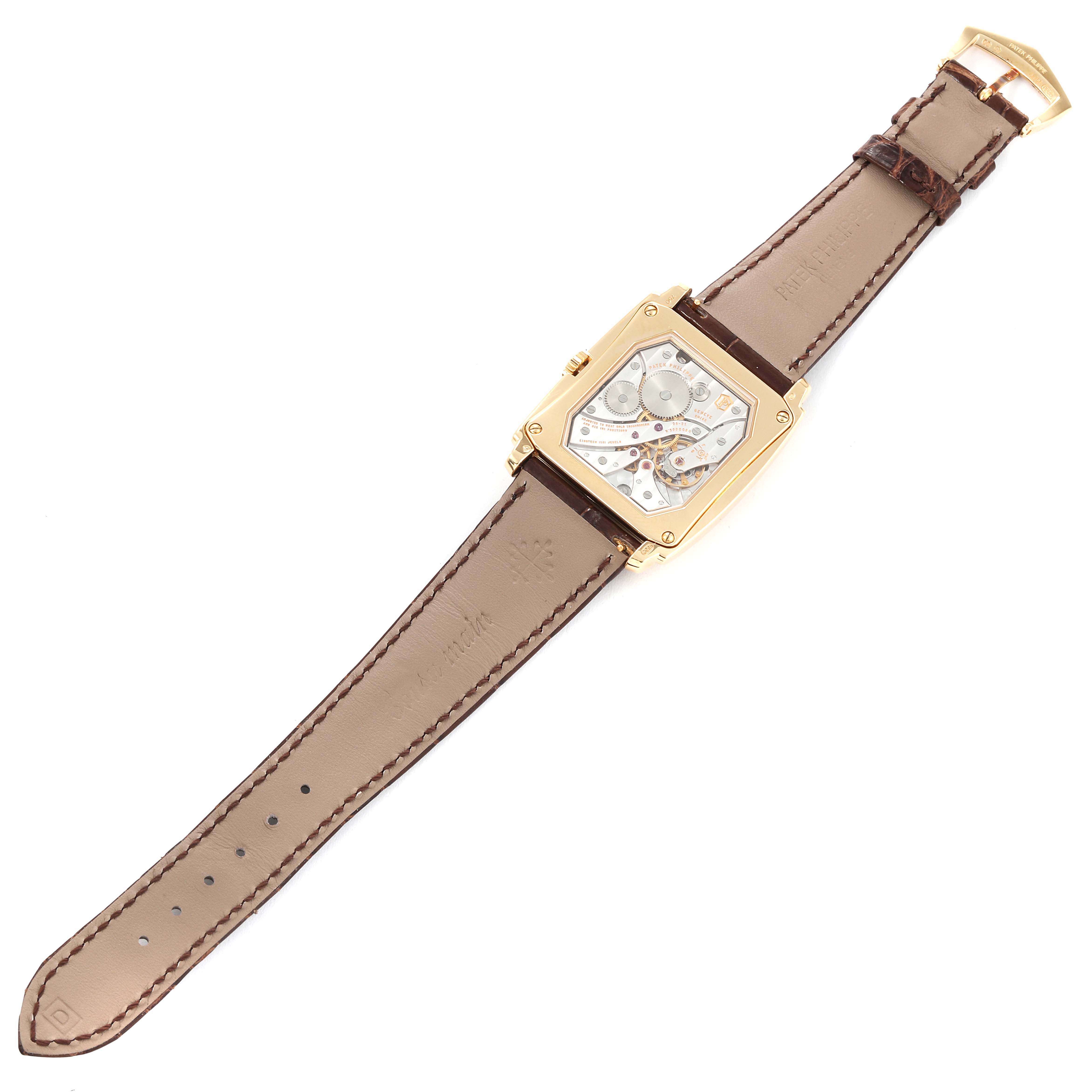 This image shows the back view of a Patek Philippe Gondolo 5124J Men's Yellow Gold Silver Dial 5124J Men's Yellow Gold Silver Dial model watch, revealing its movement and leather strap.