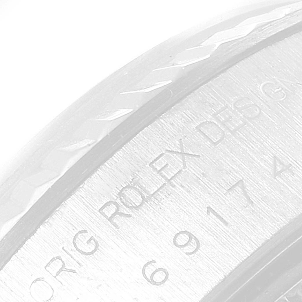 The image shows an angled close-up of the engraved text on the case back of a Rolex Datejust 69174 Women
s Stainless Steel Silver Dial 69174 Women
s Stainless Steel Silver Dial watch.