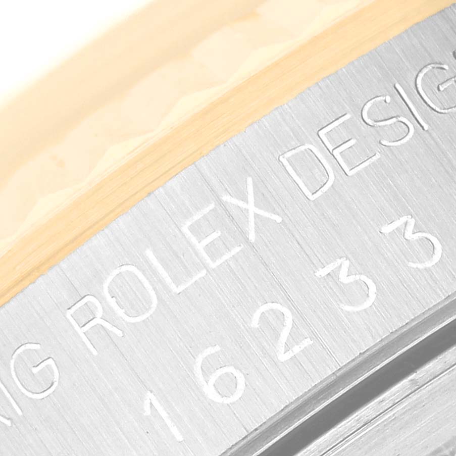 The image shows the engraved serial number and design text on the side of a Rolex Datejust 16233 Men's Steel and Gold (two tone) Silver Dial 16233 Men's Steel and Gold (two tone) Silver Dial watch case.