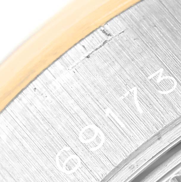 The image shows a close-up of the serial numbers on the side of a Rolex Datejust 69173 Women's Steel and Gold (two tone) Blue Dial 69173 Women's Steel and Gold (two tone) Blue Dial watch bezel.