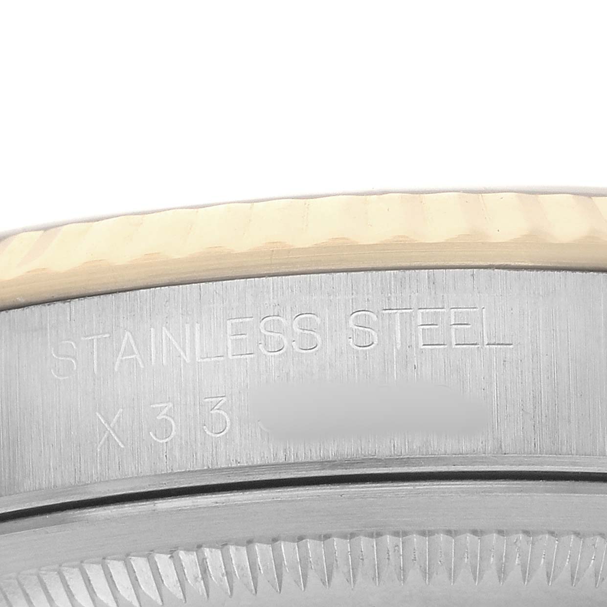 The image shows a close-up angle of the Rolex Datejust 16233 Men's Steel and Gold (two tone) Champagne Dial's fluted bezel and part of its stainless steel case back.