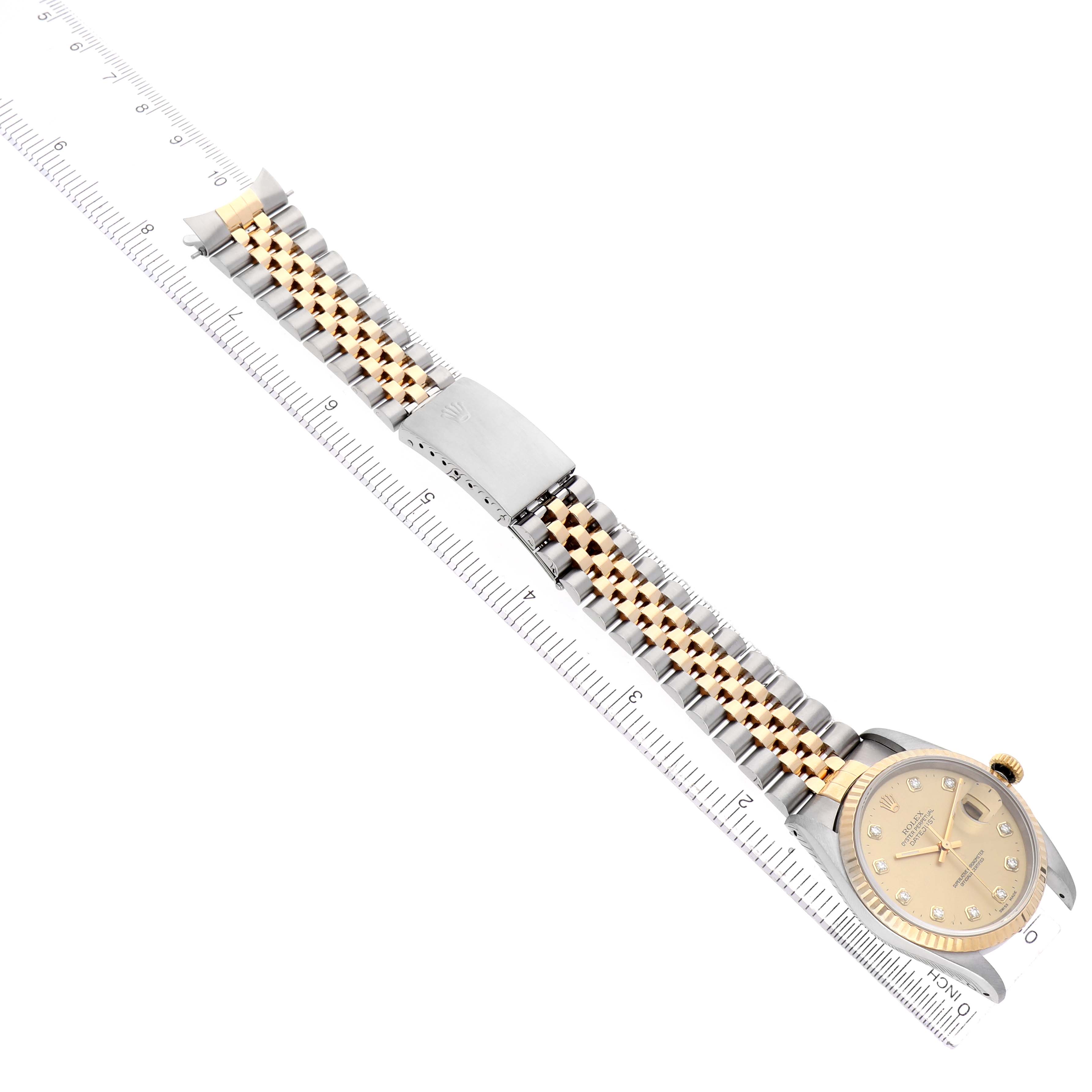 The Rolex Datejust 16233 Men's Steel and Gold (two tone) Champagne Dial watch is shown from a top-down angle, highlighting the bracelet, clasp, and face with a ruler beside it.