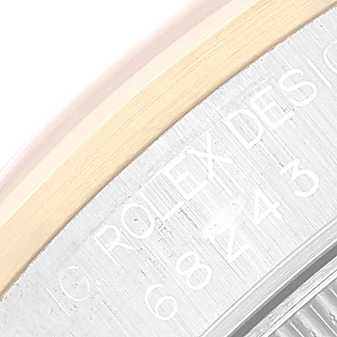 The image shows a close-up of the Rolex Mid-Size 68243 Women
s Steel and Gold (two tone) Black Dial 68243 Women
s Steel and Gold (two tone) Black Dial model
s engraved bezel and case.