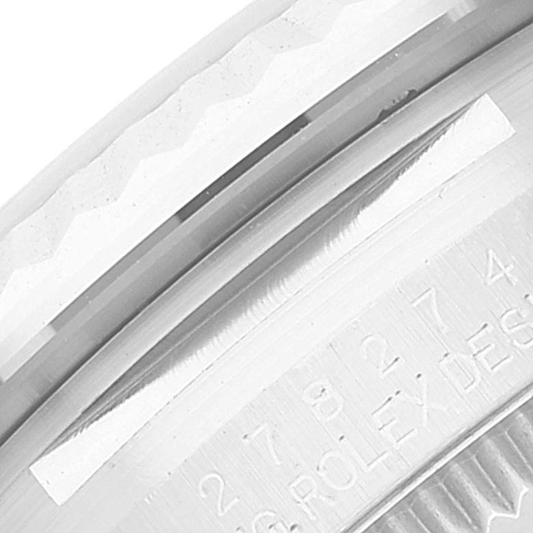 This close-up of the Rolex Mid-Size 278274 Women's Stainless Steel Blue Dial 278274 Women's Stainless Steel Blue Dial model shows a portion of the case back with engraved numbers and markings.
