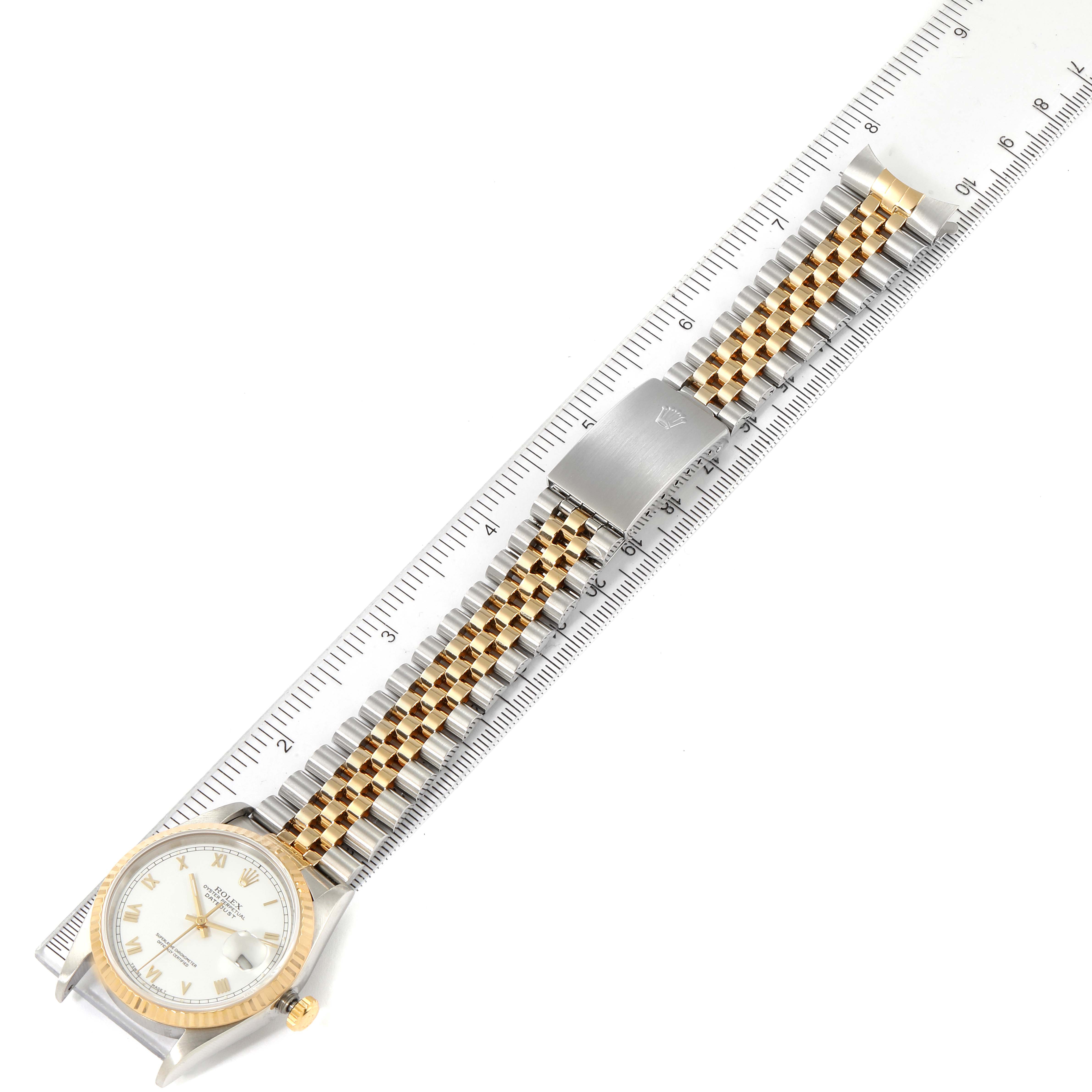 The image shows a Rolex Datejust 16233 Men's Steel and Gold (two tone) White Dial 16233 Men's Steel and Gold (two tone) White Dial watch laid flat with its two-tone bracelet and clasp measured against a ruler.