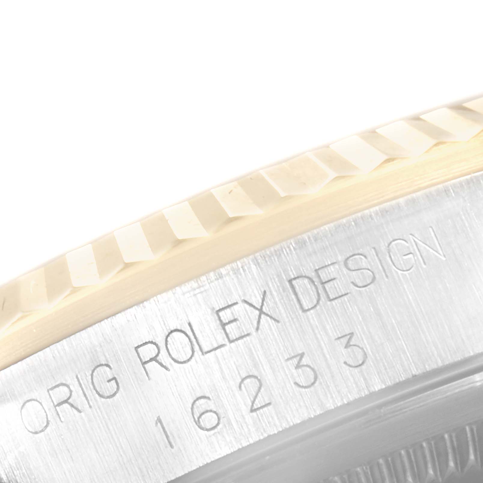 This close-up image shows the engraved bezel and case edge of a Rolex Datejust 16233 Men's Steel and Gold (two tone) White Dial 16233 Men's Steel and Gold (two tone) White Dial watch.