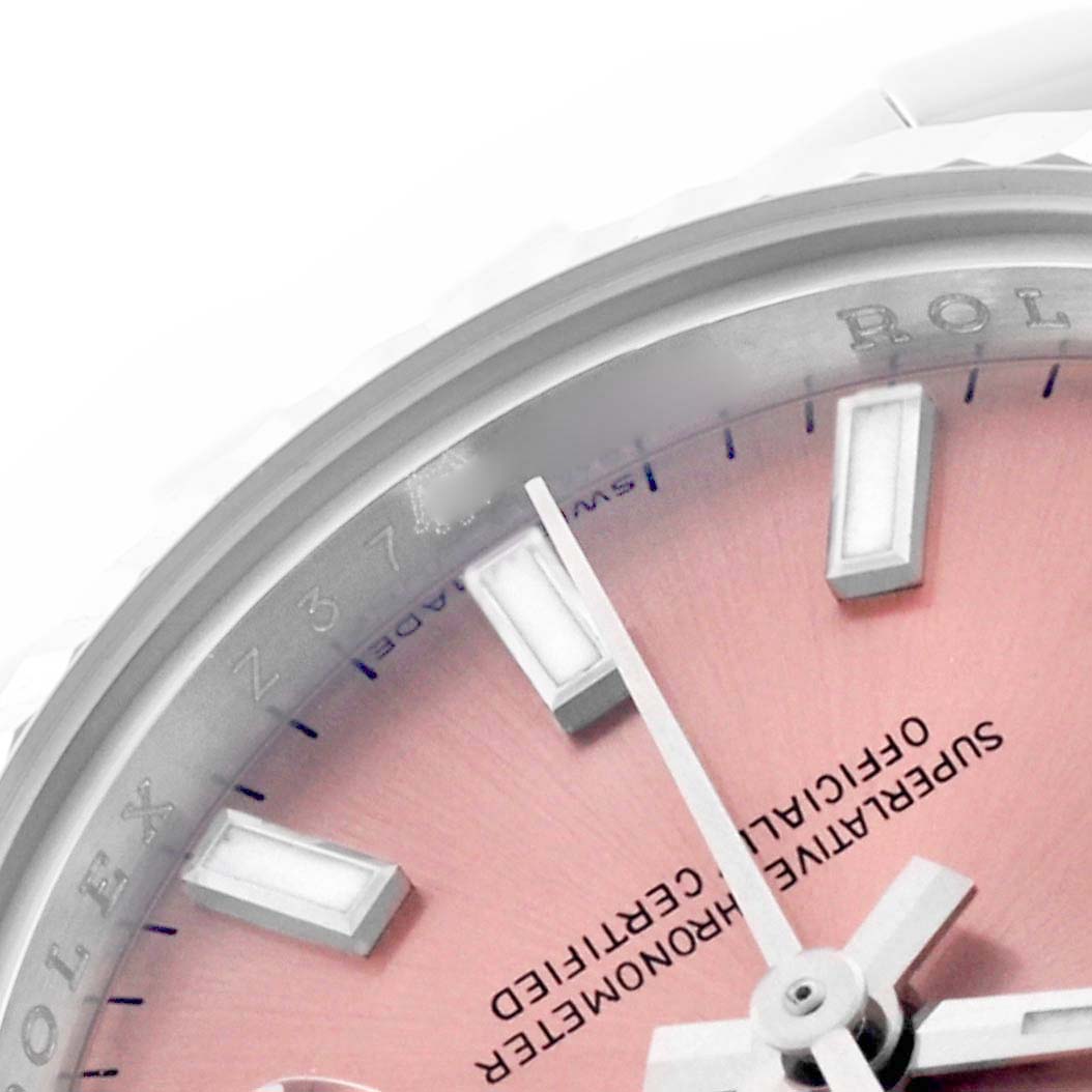 The image shows a close-up of a Rolex Datejust 179174 Women's Steel and Gold (two tone) Pink Dial 179174 Women's Steel and Gold (two tone) Pink Dial dial with silver indices and a partial view of the bezel.