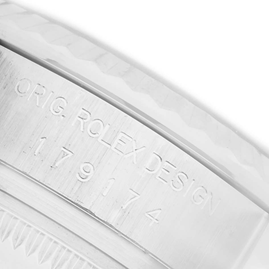 The image shows a close-up of the case edge of a Rolex Datejust 179174 Women's Steel and Gold (two tone) Pink Dial 179174 Women's Steel and Gold (two tone) Pink Dial, highlighting the engraved serial number and texture.